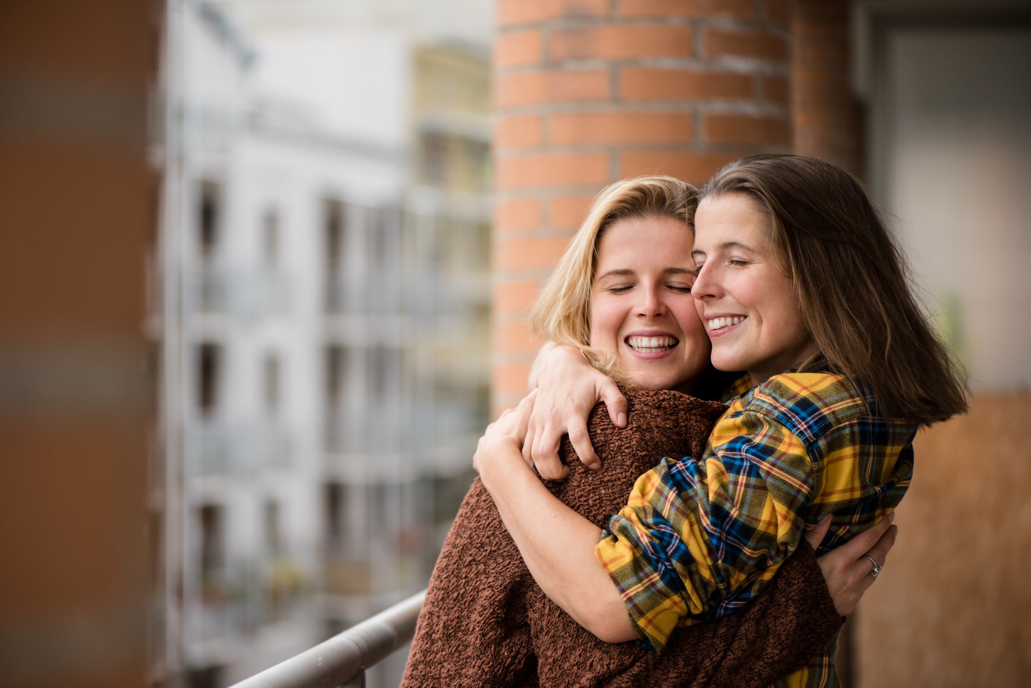 Foto von Zwillingsmädchen, die lächeln und sich umarmen. | Quelle: Getty Images