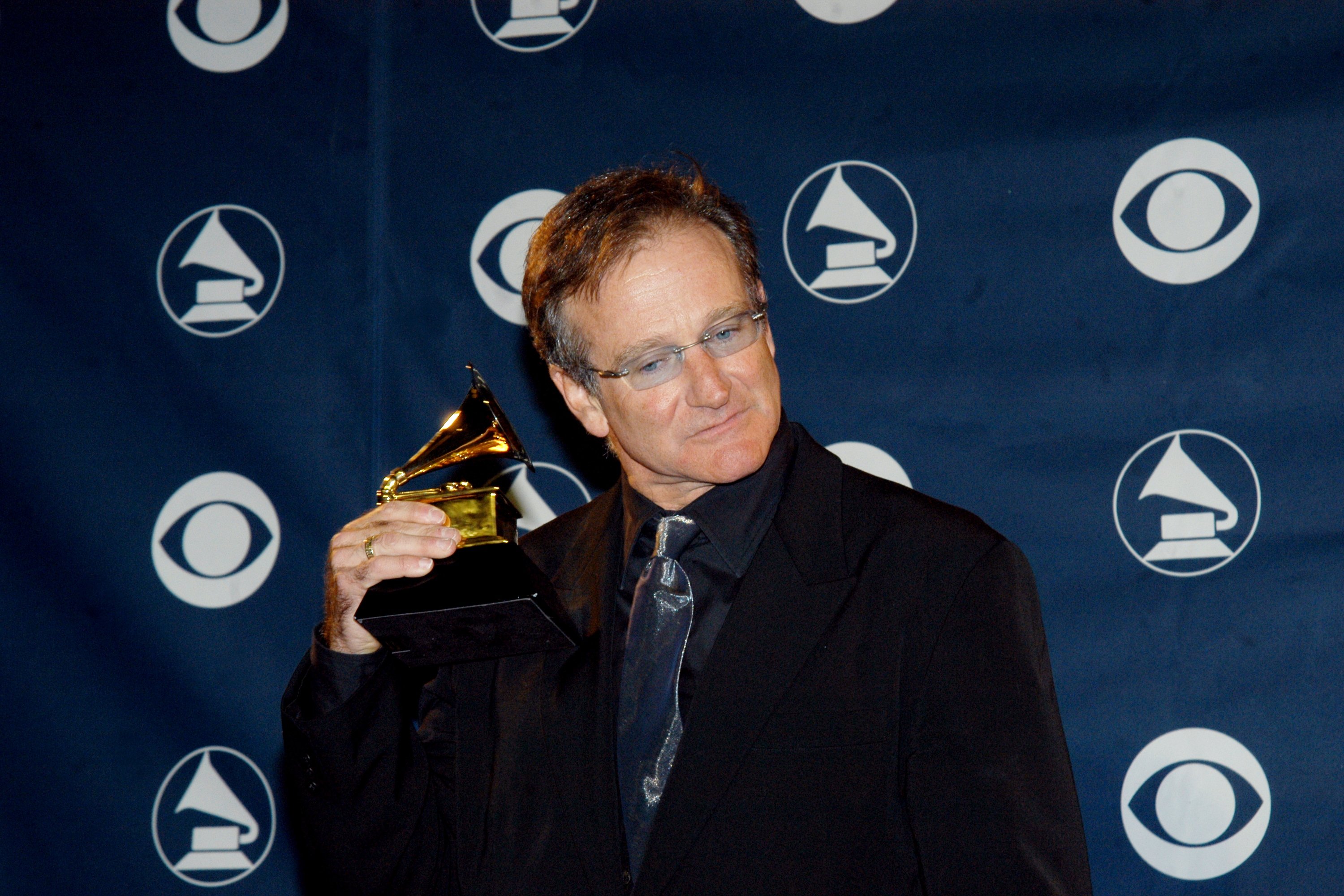 Robin Williams holds his award for Best Spoken Comedy Album backstage at the 45th annual Grammy Awards on February 23, 2003, at Madison Square Garden. | Source: Getty Images