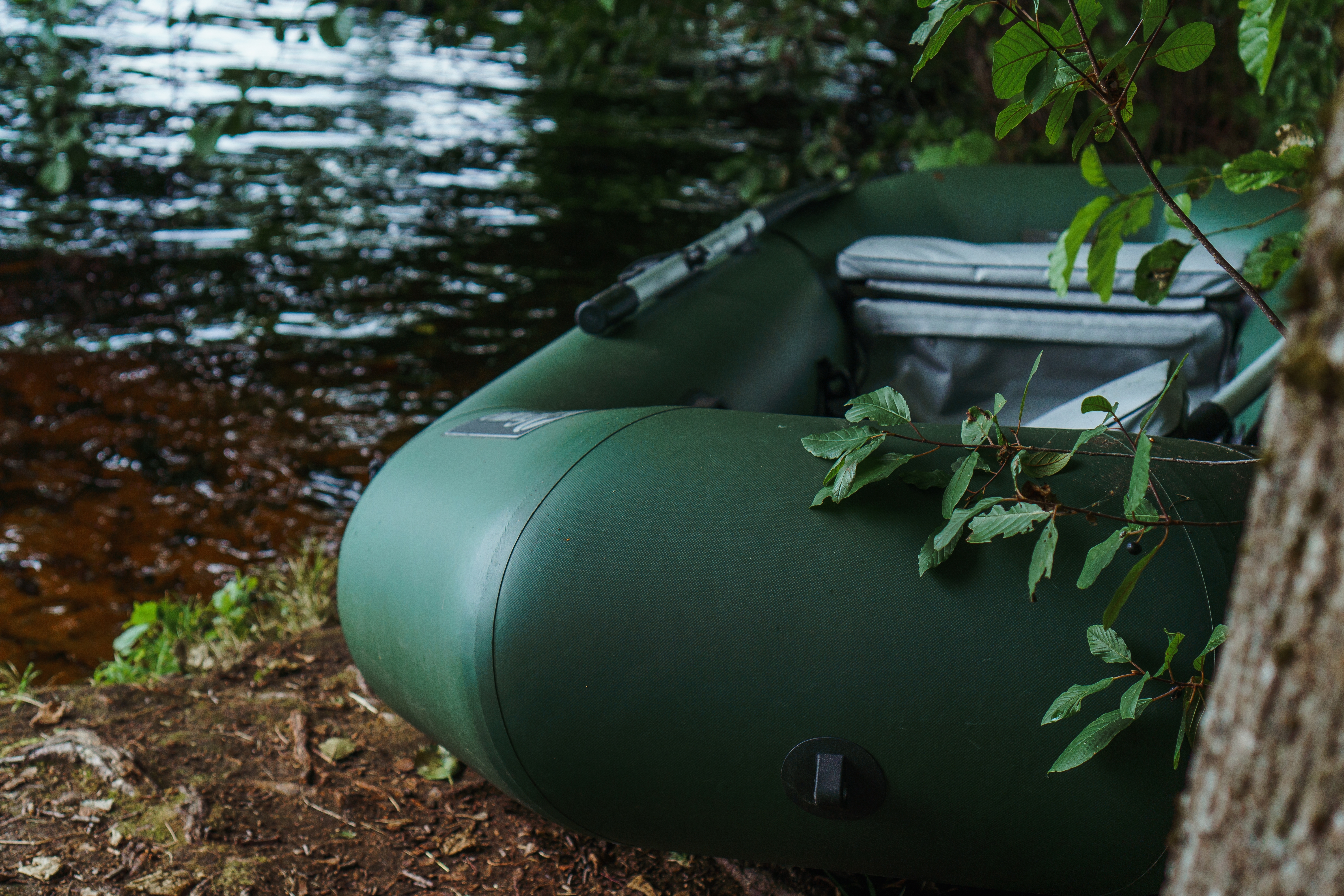 Modern green inflatable boat parked on shore. | Source: Shutterstock