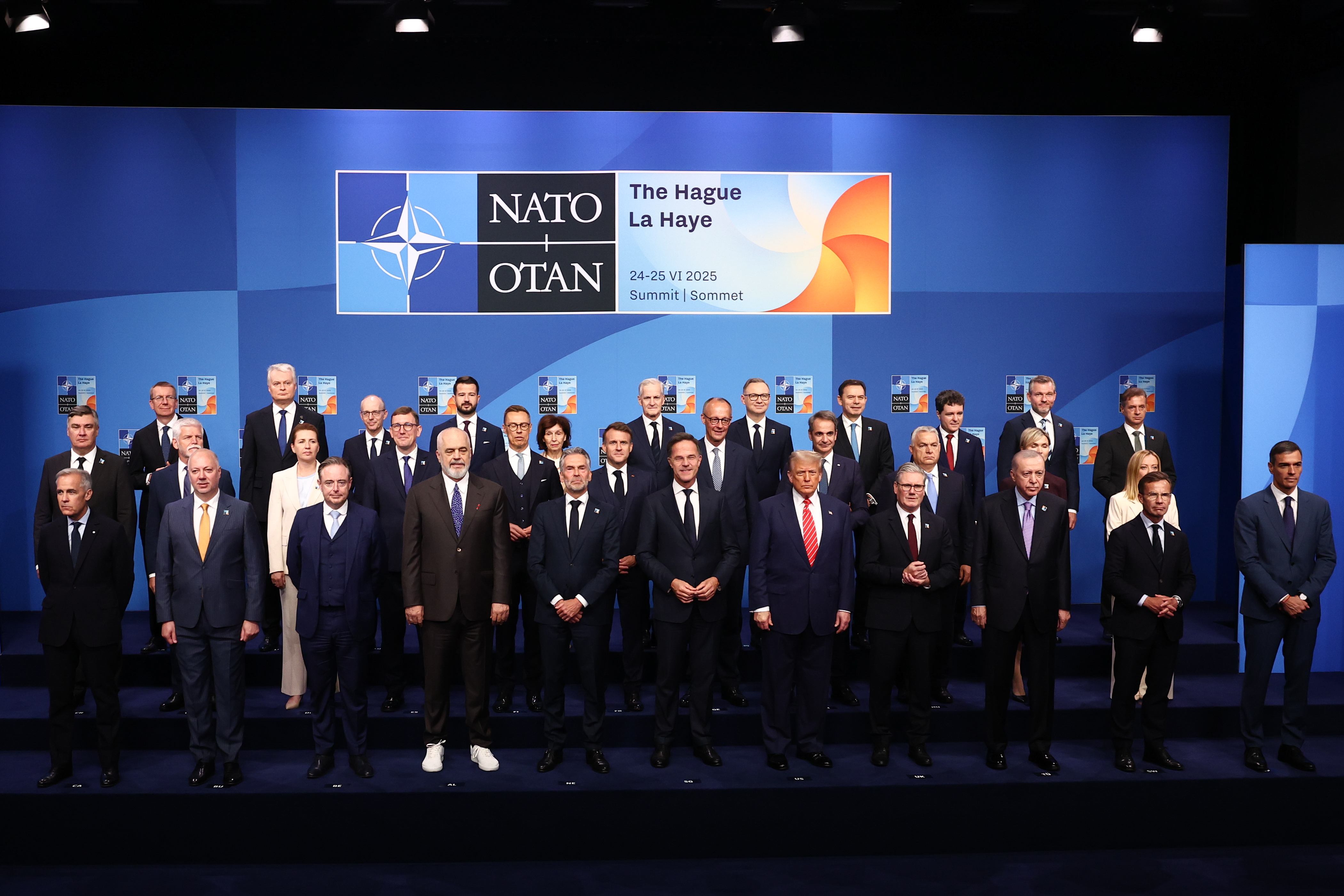 A wider shot offers a fuller view of the gathering, capturing not only Trump and Schoof but also several of the world’s female leaders standing confidently among their male counterparts. Dressed in elegant suits, the women add both presence and poise to the official photo.