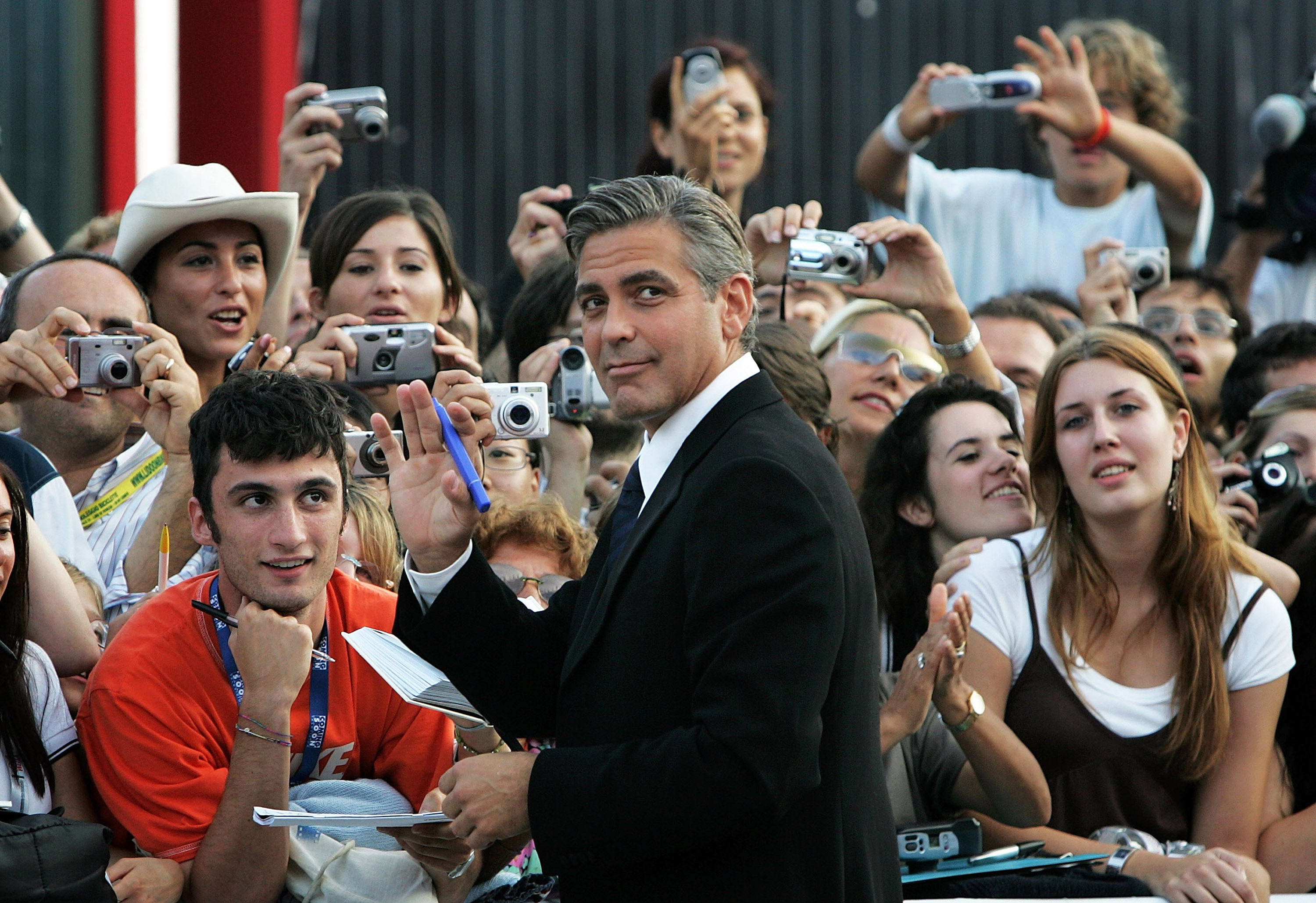 George Clooney signs autographs as he arrives for the Golden Lion Awards at the Palazzo del Cinema in Venice, Italy on September 10, 2005 | Source: Getty Images