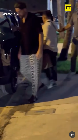 Travis Kelce making his way around his and Taylor Swift's black vehicle. | Source: Instagram/entertainmenttonight