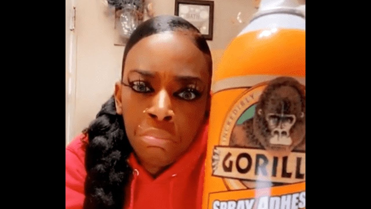 Tessica Brown holding a Gorilla Glue container moments before spraying it on her hair. | Photo: YouTube/ SC Reviews