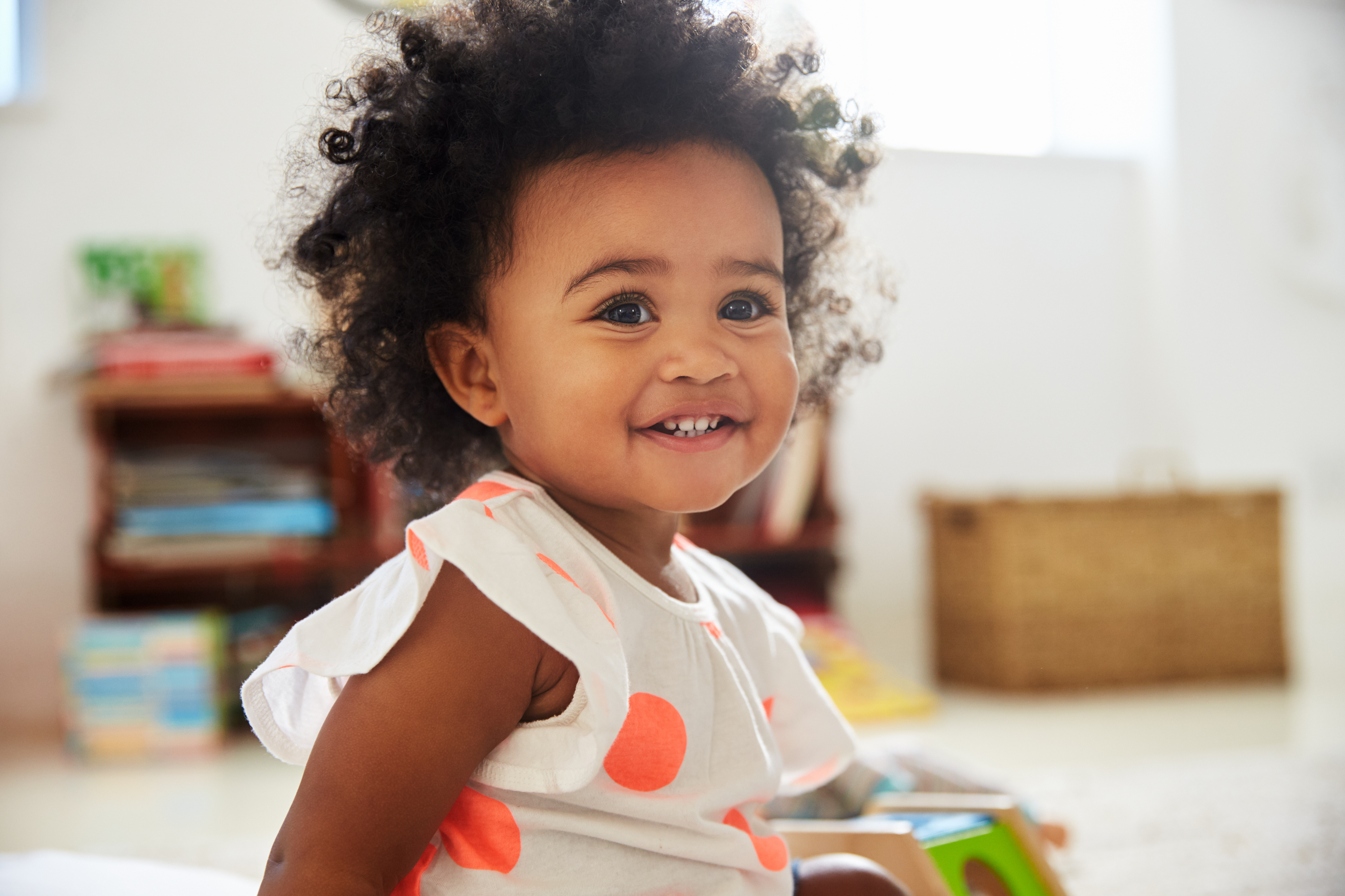 A little girl smiling in a playroom | Source: Shutterstock