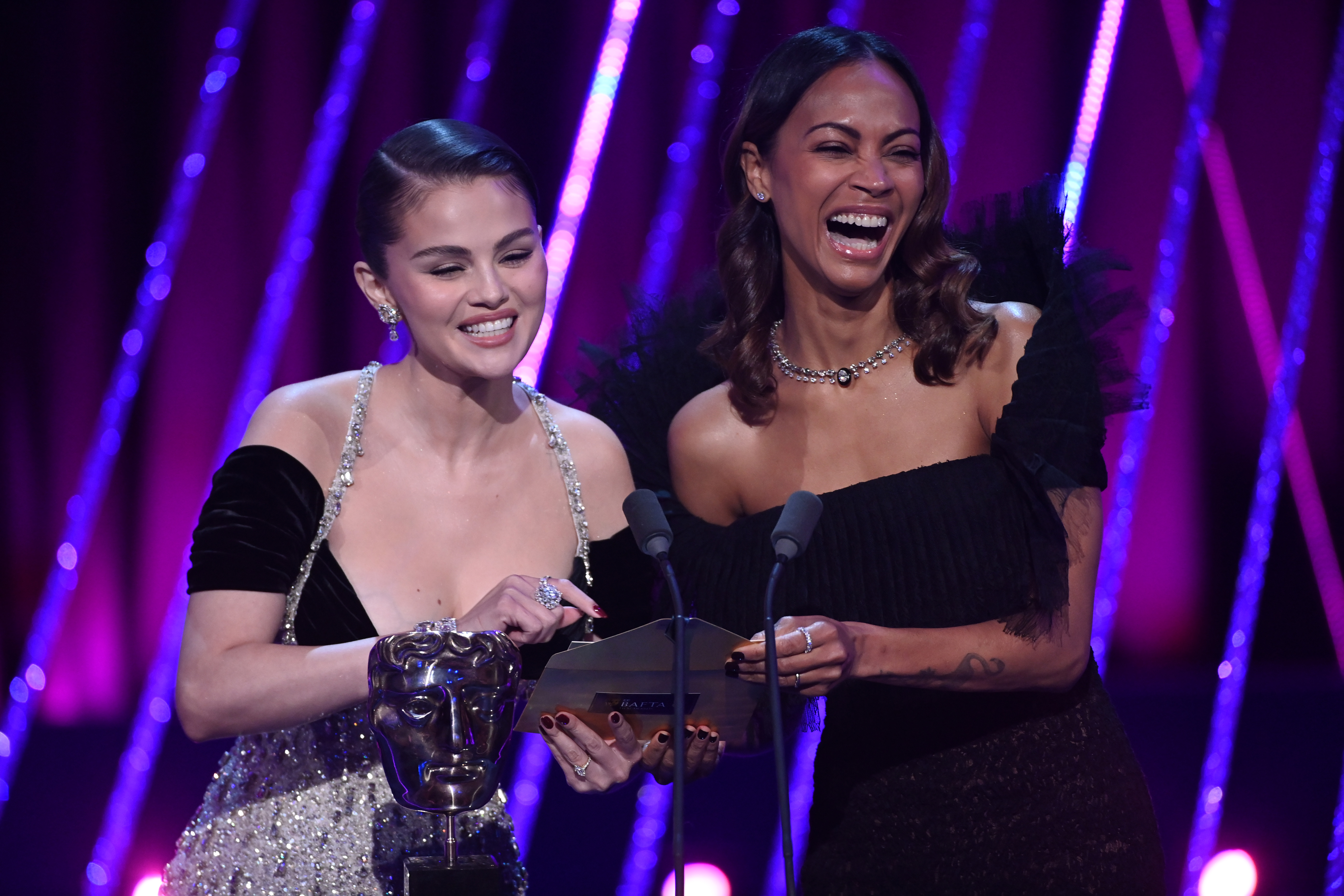 Selena Gomez and Zoe Saldaña present the Outstanding Debut by a British Writer, Director, or Producer on stage during the EE BAFTA Film Awards 2025 in London, England, on February 16, 2025 | Source: Getty Images