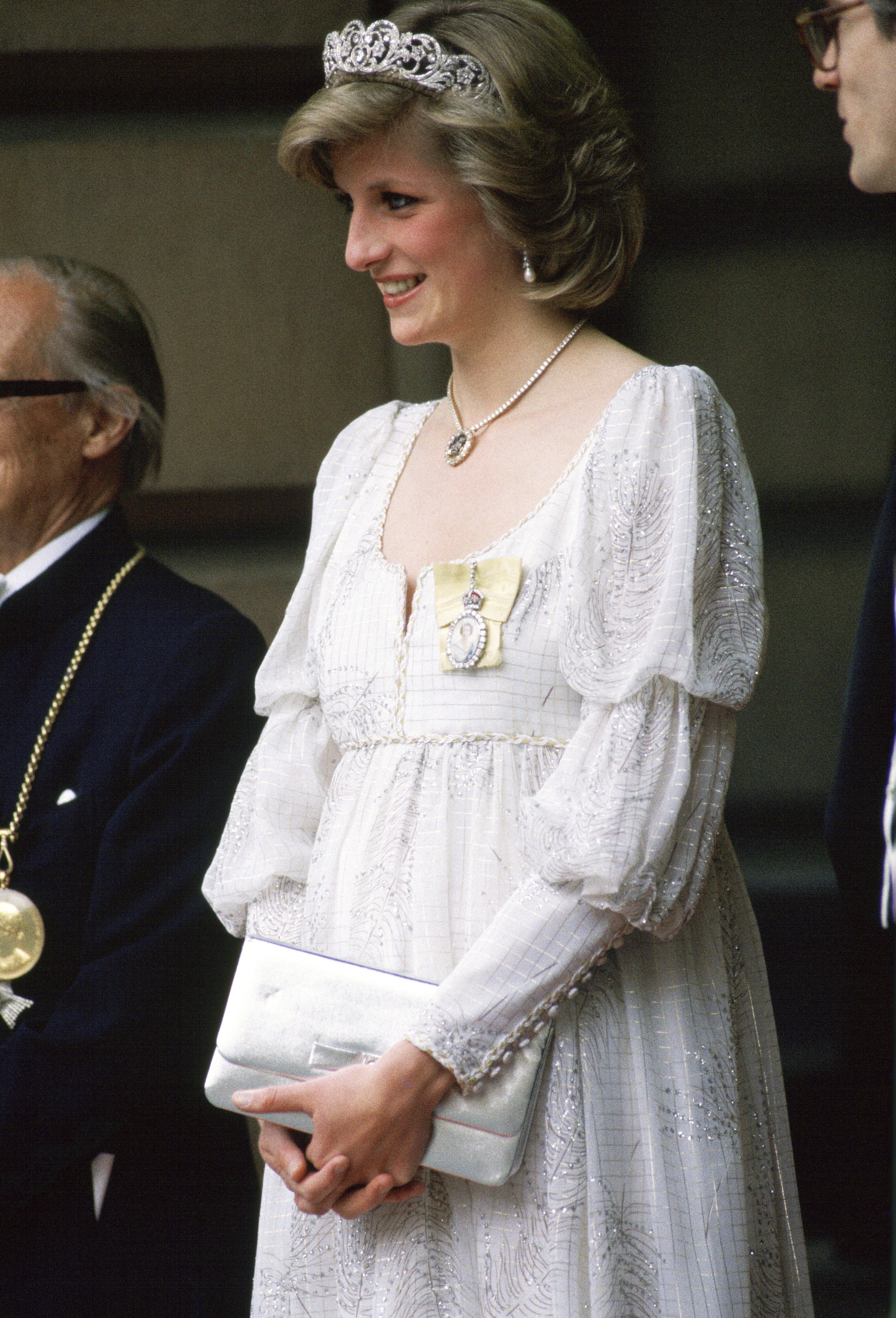 Princess Diana wearing a maternity dress with the Spencer family Tiara, Royal Family Orders and a diamond necklace In the shape of the Prince Of Wales feathers an event at the Royal Academy on May 14, 1984 | Source: Getty Images