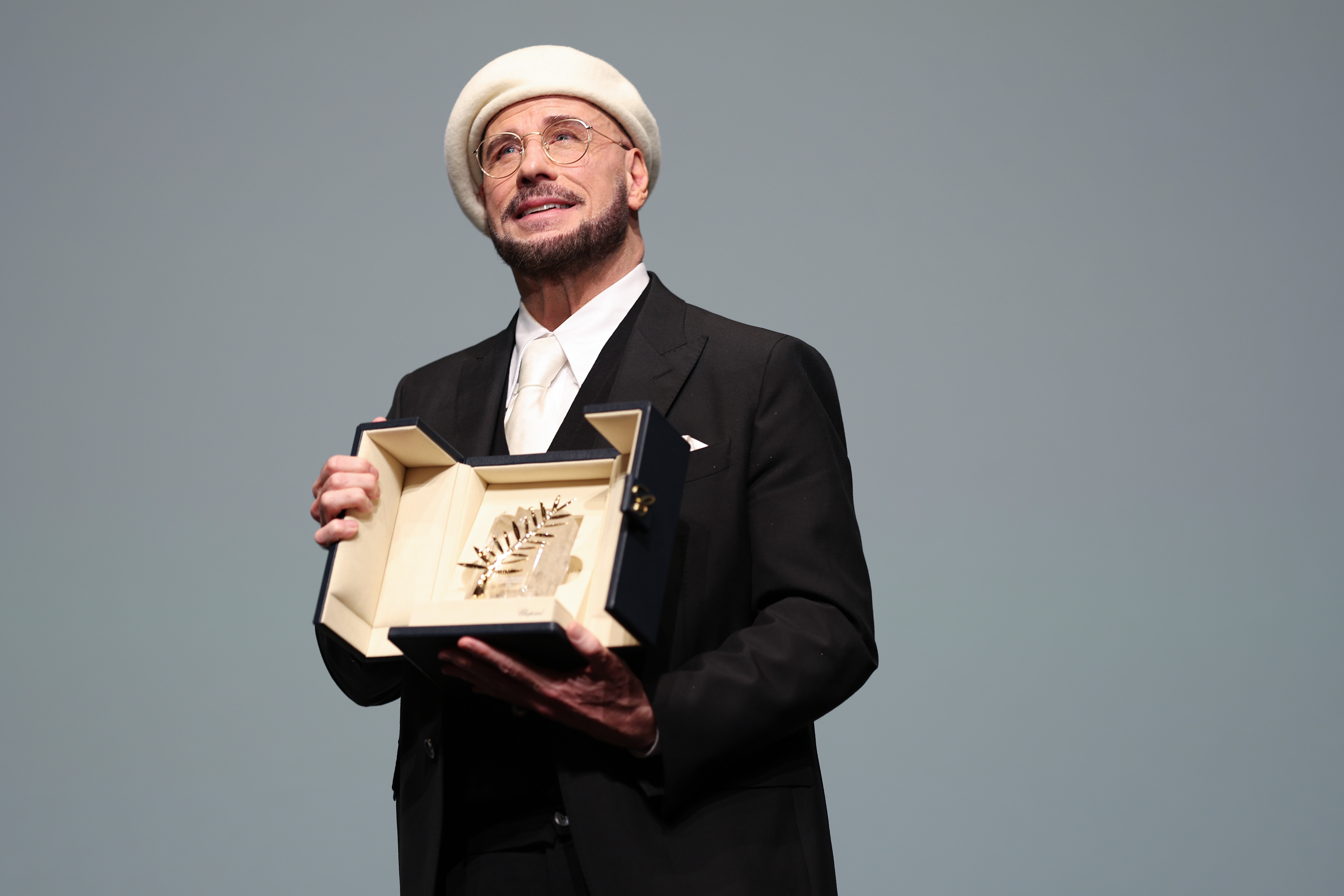 John Travolta accepts the Honorary Palme Award onstage during the 79th annual Cannes Film Festival at Plage Macé on May 15, 2026 in Cannes, France. | Source: Getty Images