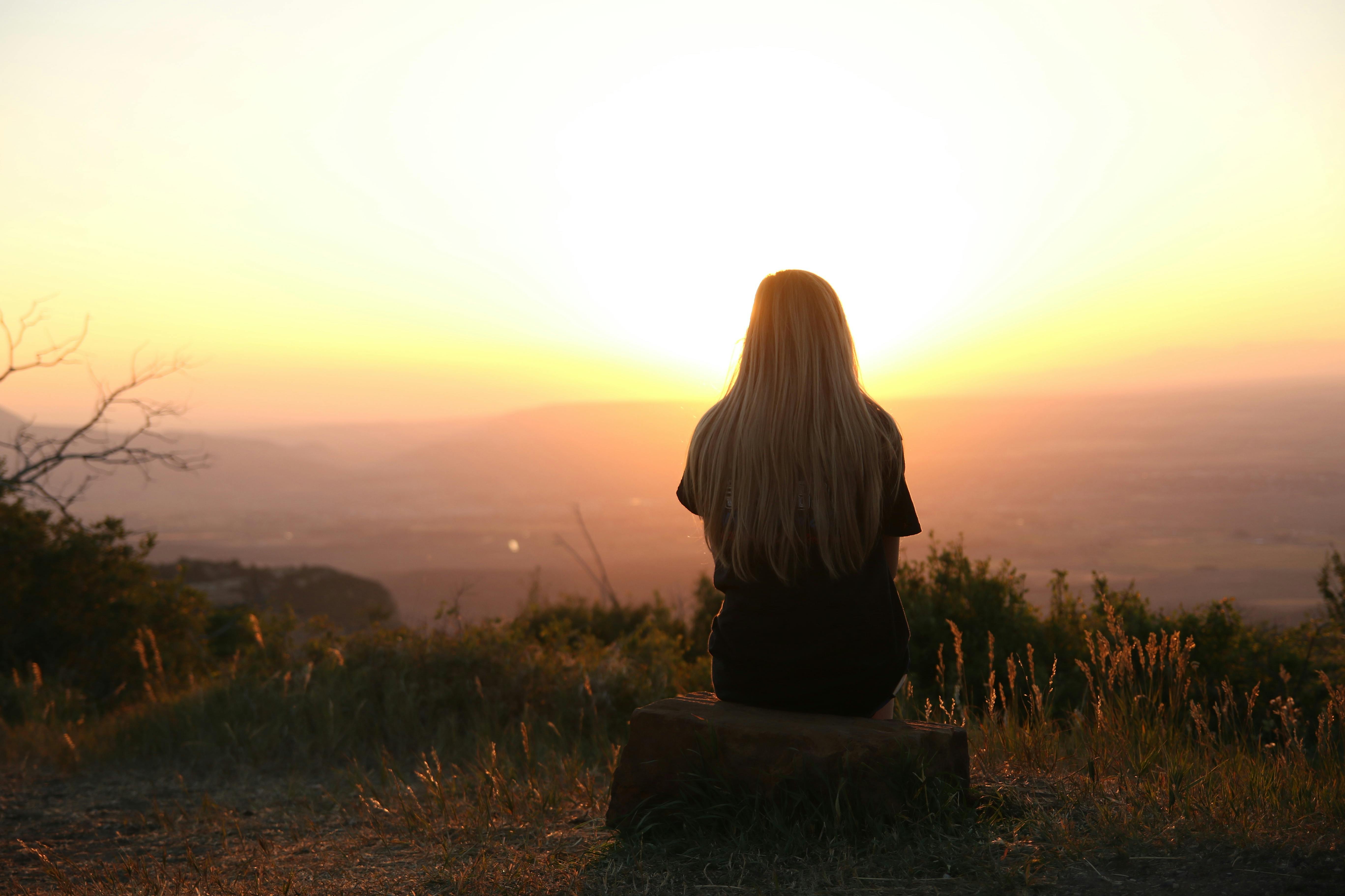 Uma mulher observando o pôr do sol | Fonte: Pexels