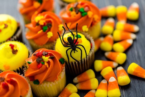 Cupcakes decorated for Halloween in yellow and orange. | Source: Shutterstock.