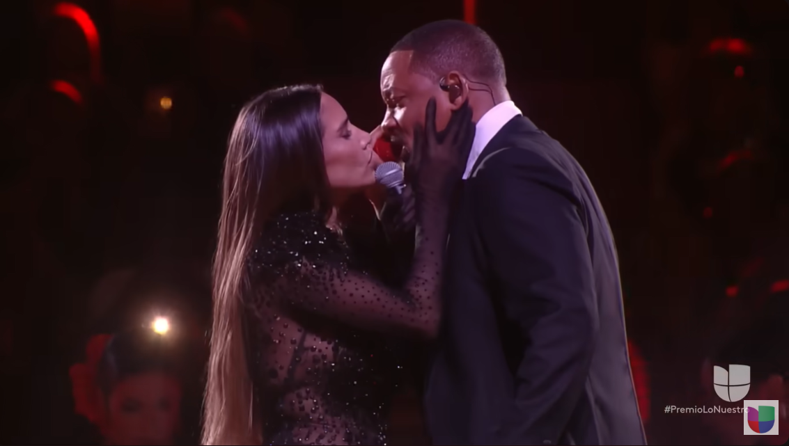 India Martínez places her hands on Will Smith's face as they share an emotionally charged onstage moment | Source: YouTube/univision