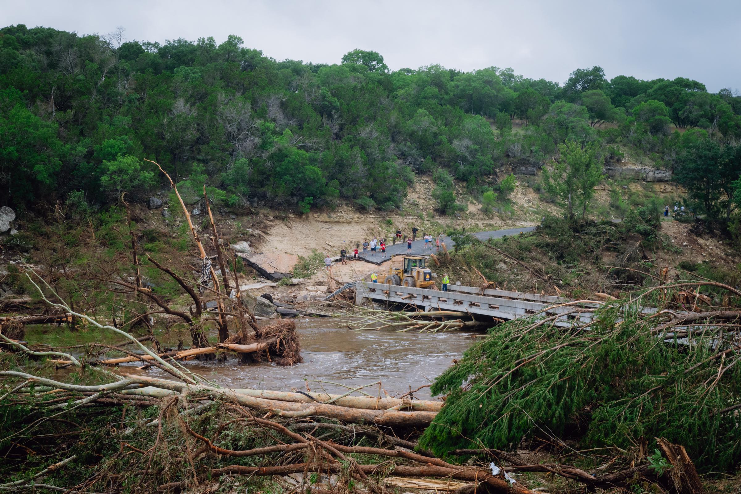 Construction crews work to clear debris for residents to cross a bridge over the Guadalupe River in Ingram, Texas on July 5, 2025. | Source: Getty Images