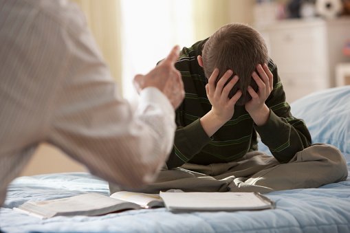 A preacher asking a young boy the question "where is God?" | Photo: Getty Images