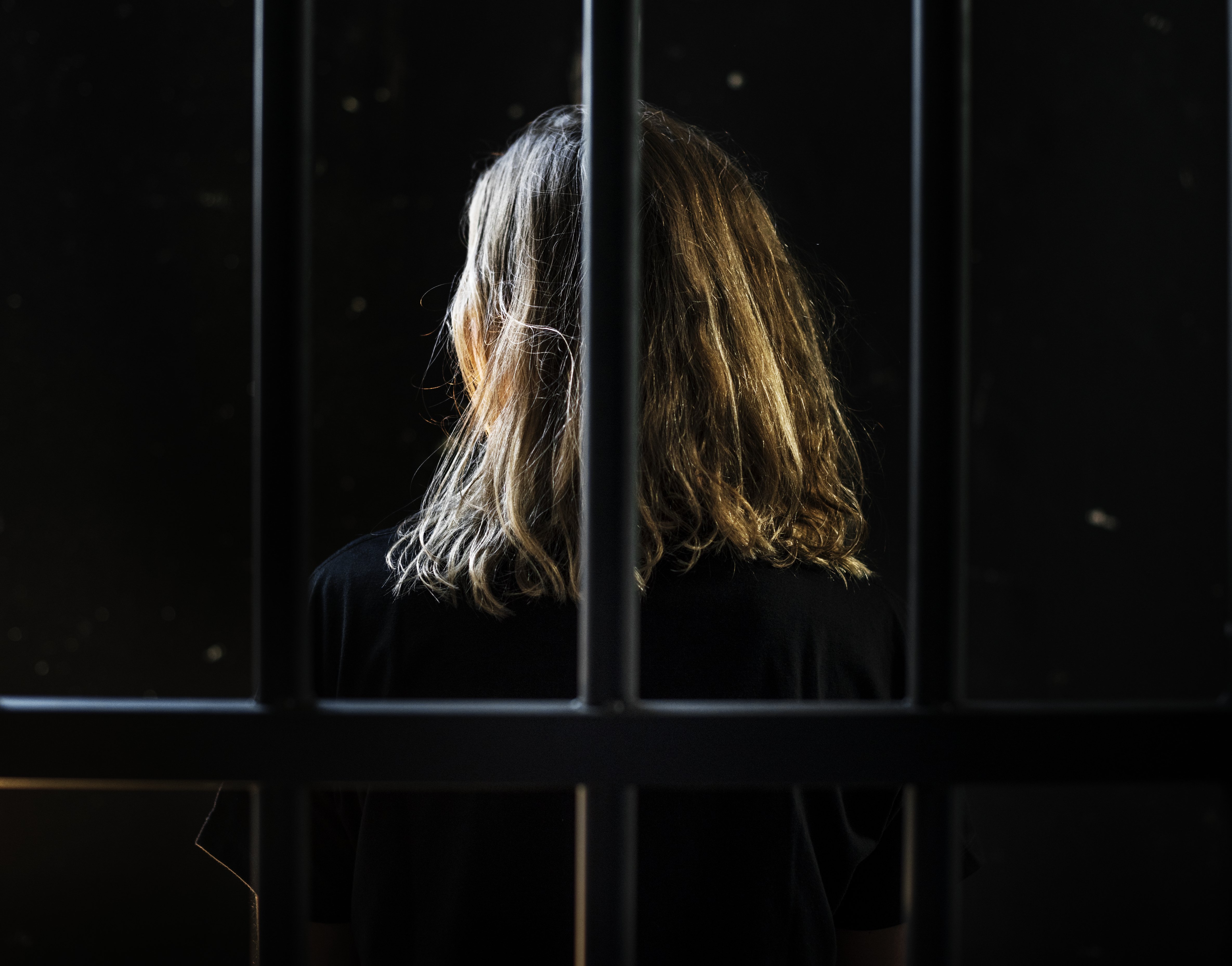 Woman behind bars. | Photo: Shutterstock