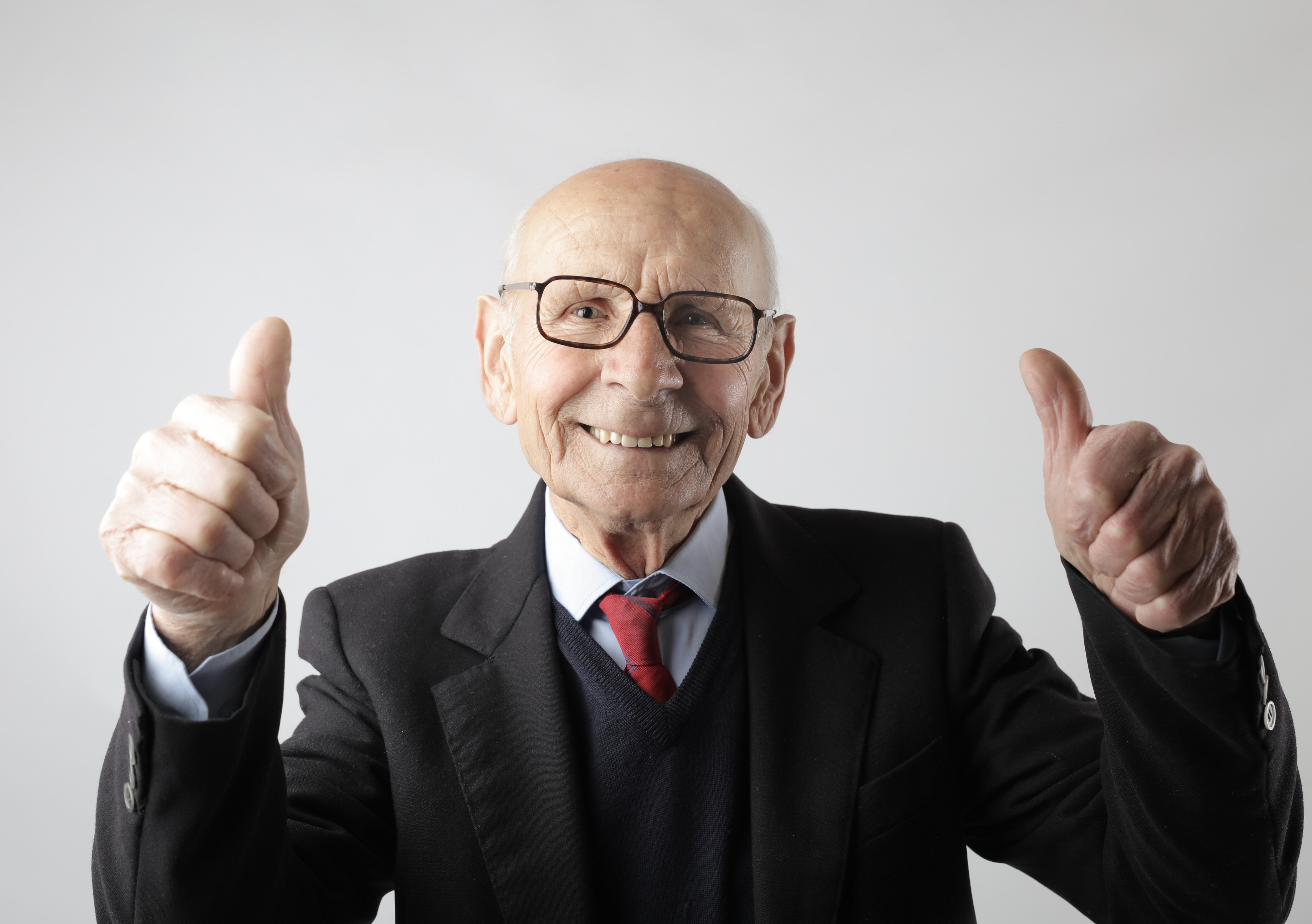 A man in a suit showing two thumbs up. | Pexels/ Andrea Piacquadio