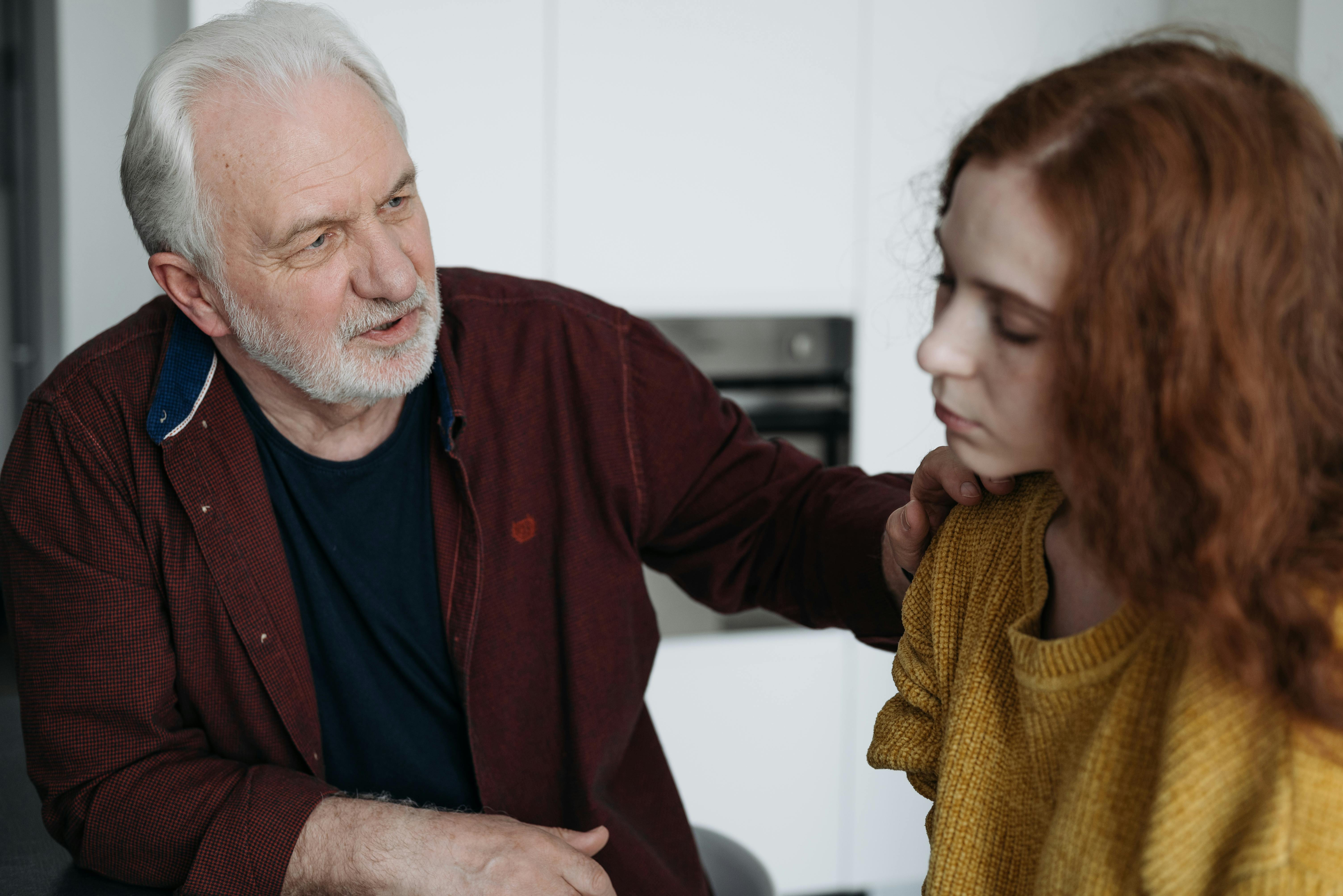 An older man talking to a younger woman | Source: Pexels