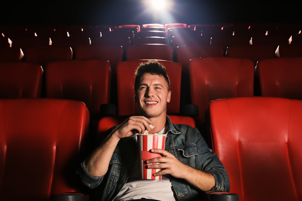 A photo of a young man watching movie in cinema. | Photo: Shutterstock