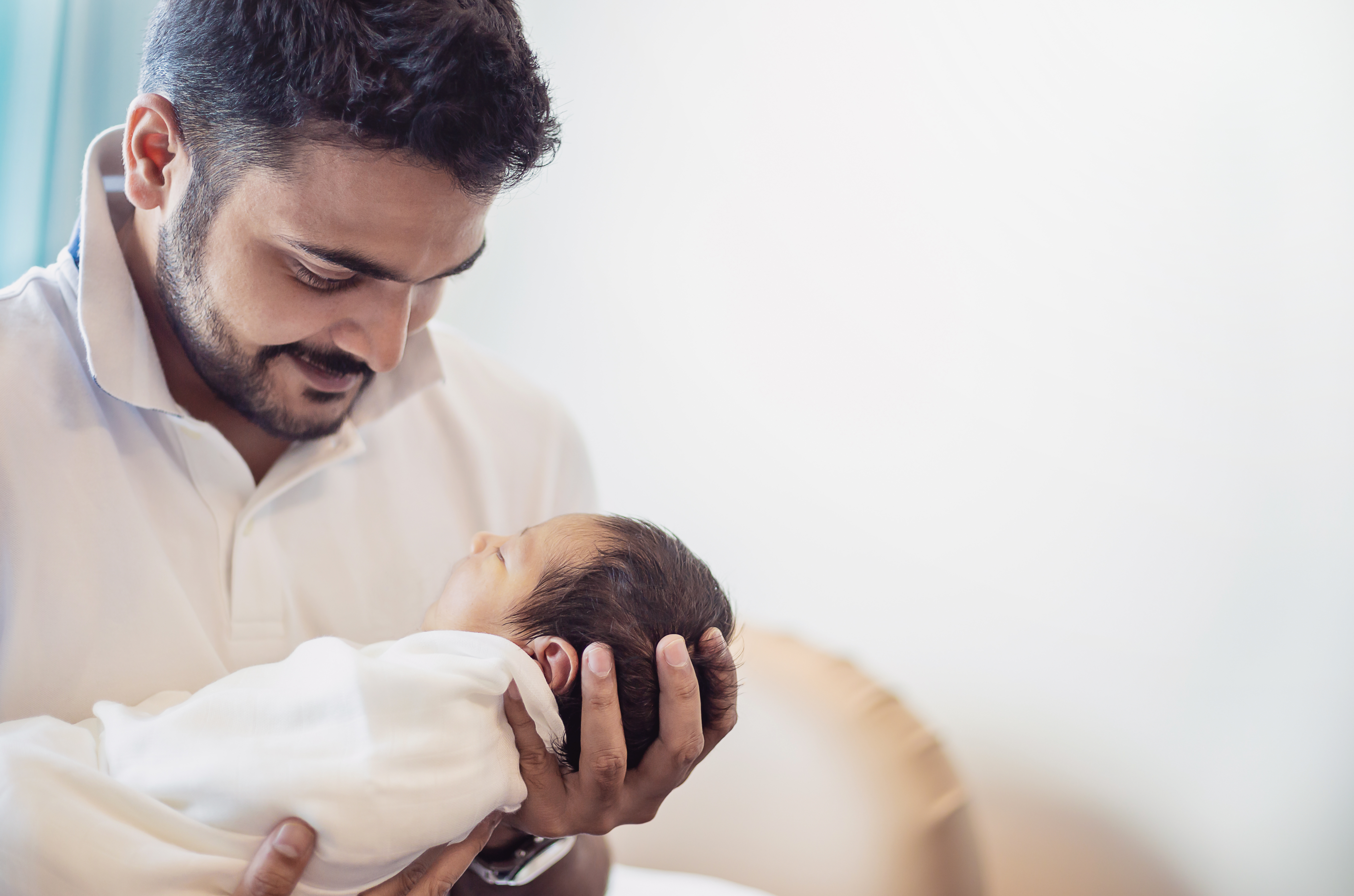 A man holding a newborn baby | Source: Shutterstock