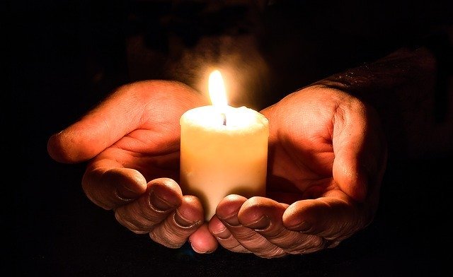 Manos juntas sosteniendo una vela. │Foto: Pixabay