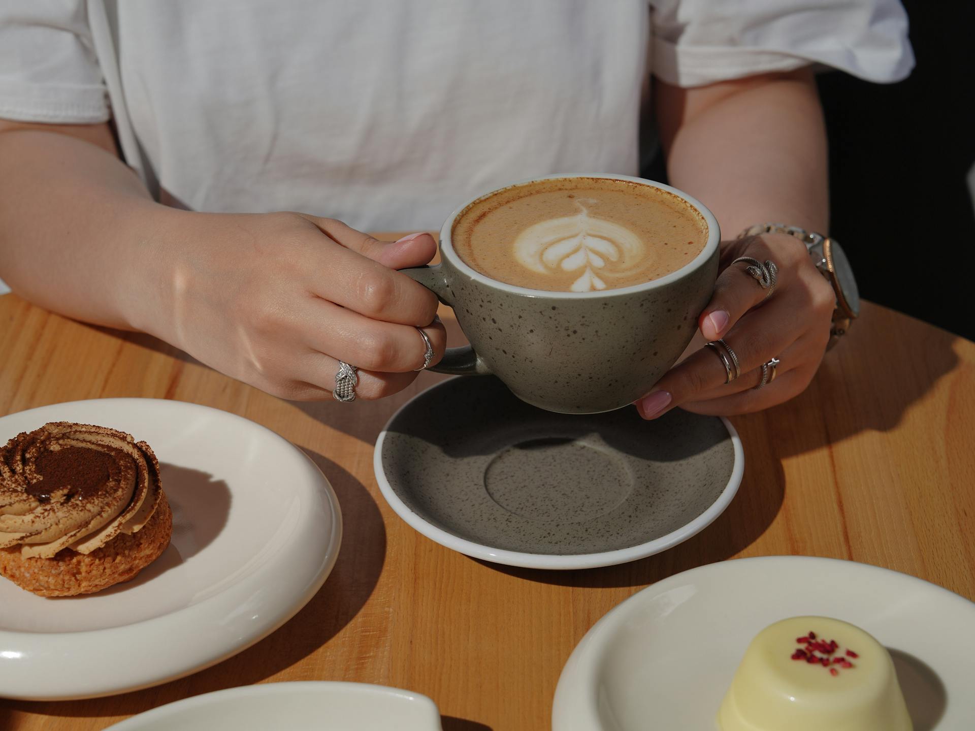 A closeup of a woman sitting at a table with a cup of coffee | Source: Pexels