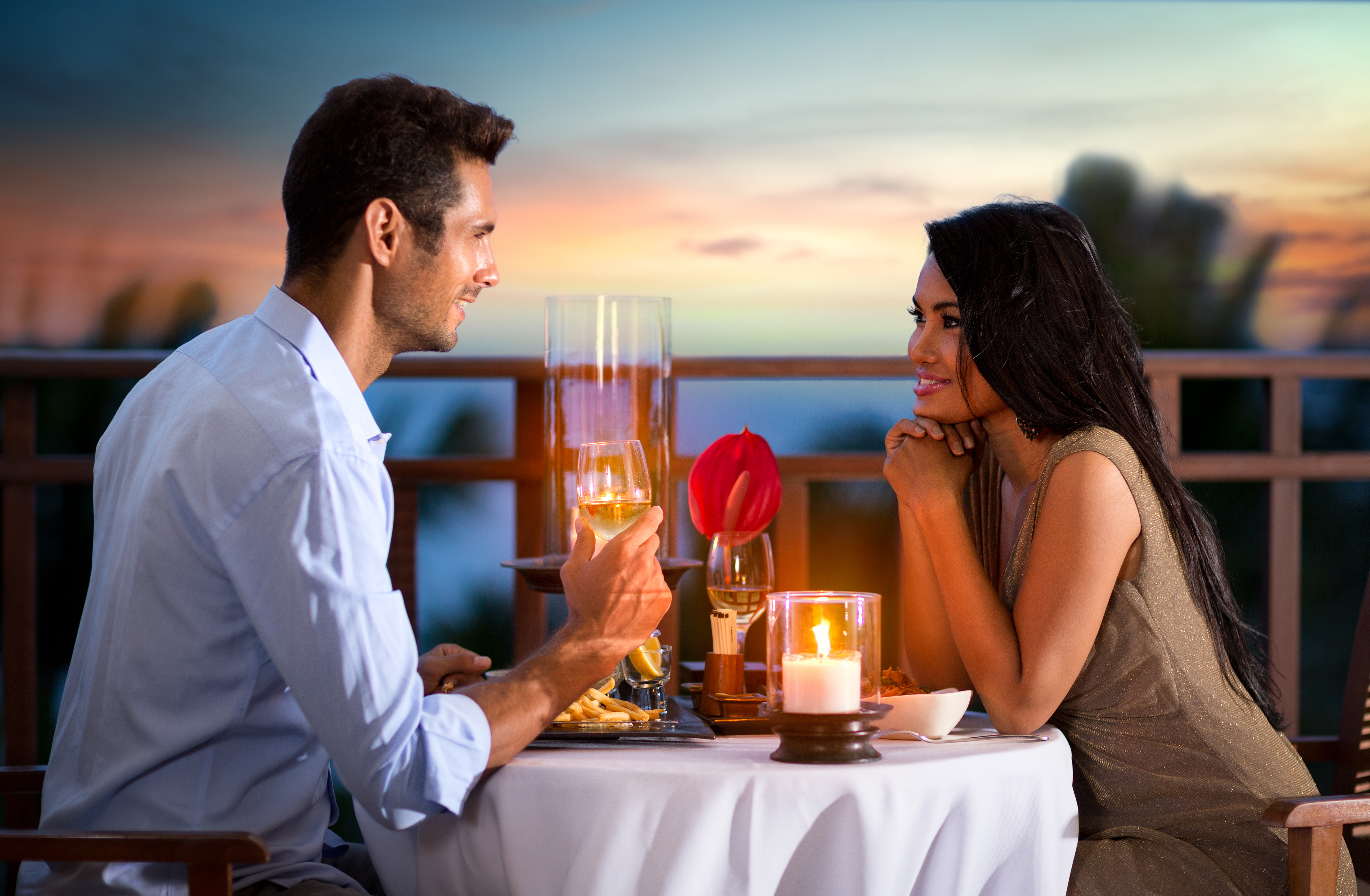 Una pareja feliz en una tarde de verano con una cena romántica al aire libre | Fuente: Shutterstock