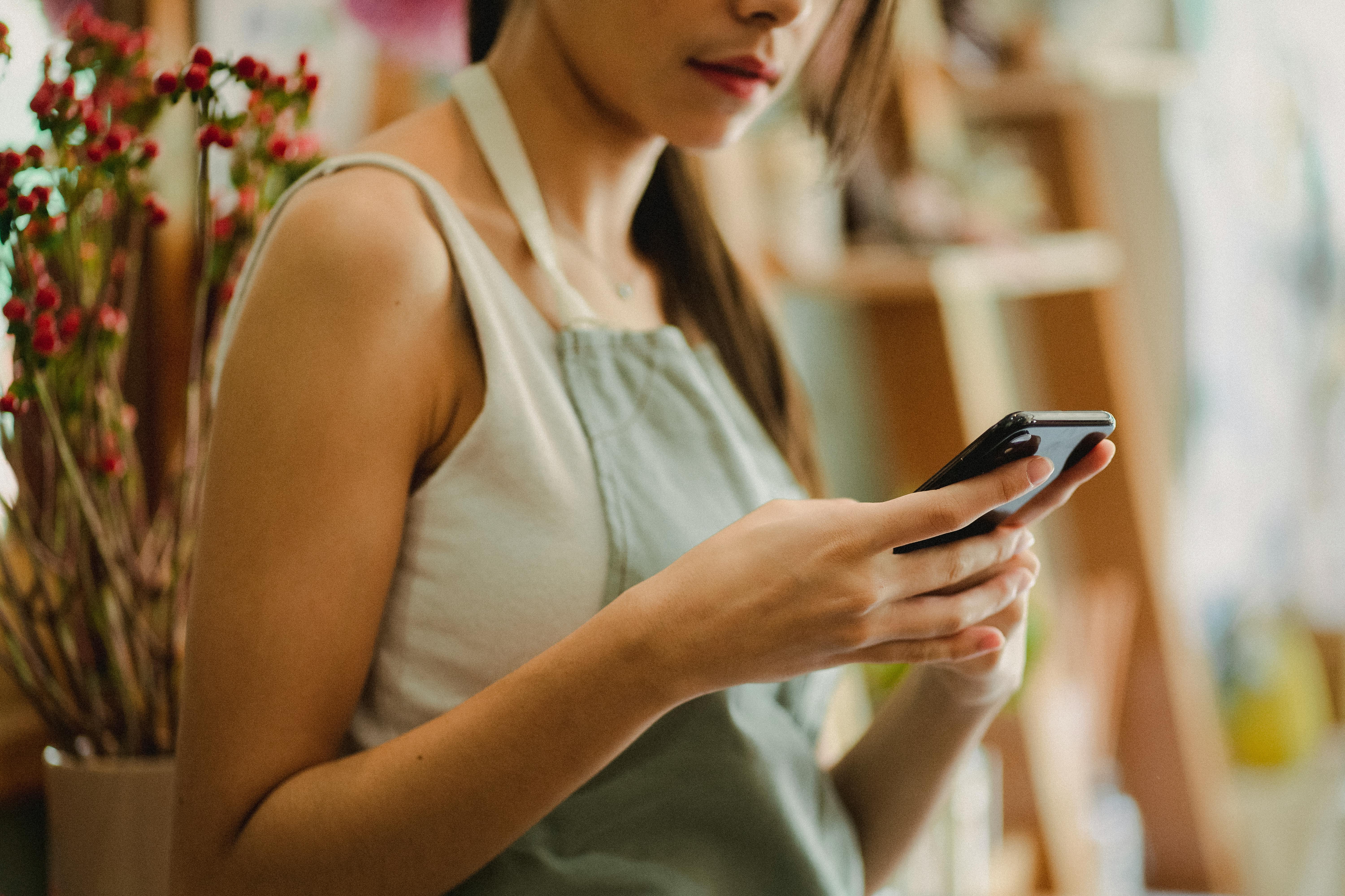 A woman with her phone | Source: Midjourney