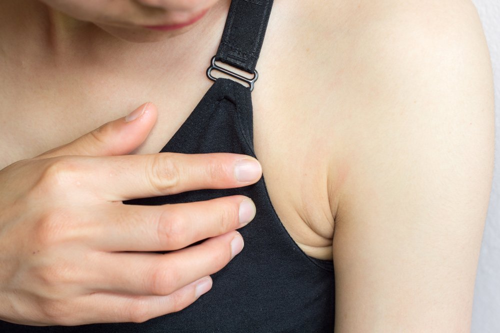 Modelo mirando su axila con preocupación. | Foto: Shutterstock