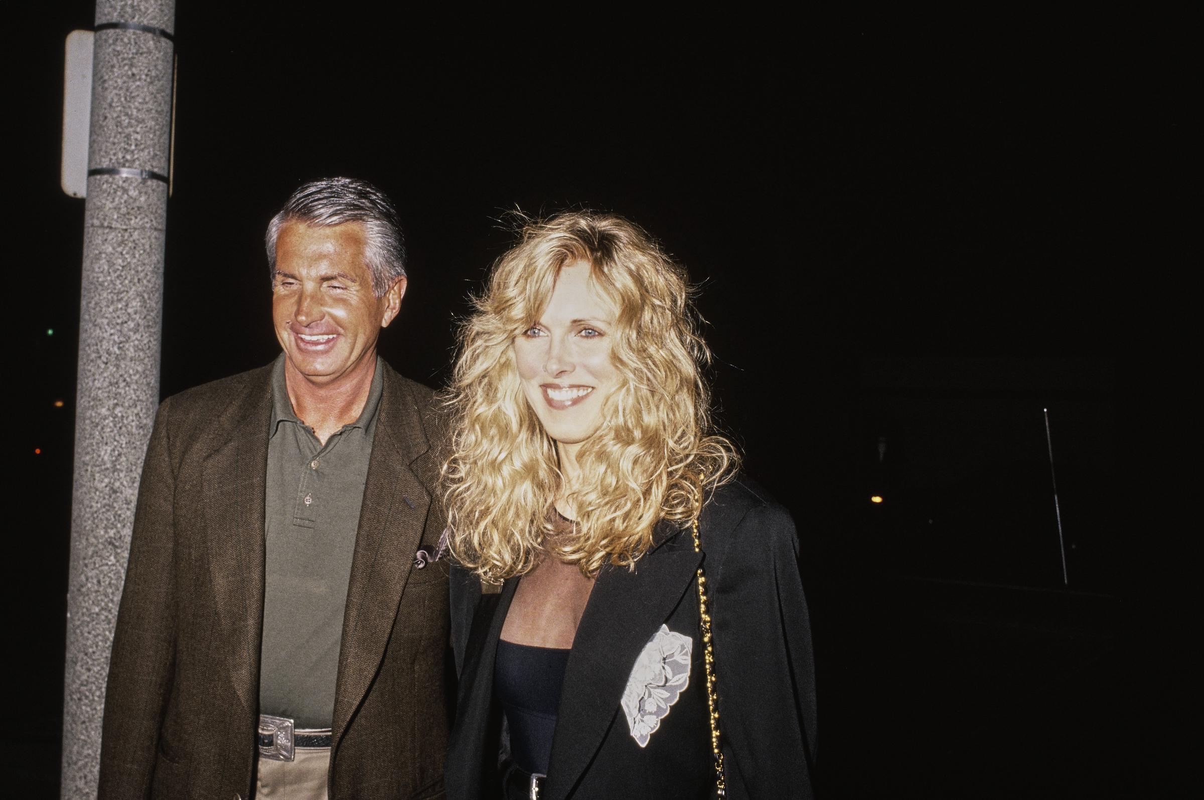 American actor George Hamilton and his former wife, American actress and model Alana Stewart, attend a birthday party for Carole Bayer Sager at Asylum restaurant in Beverly Hills, California, on March 8, 1991. | Source: Getty Images