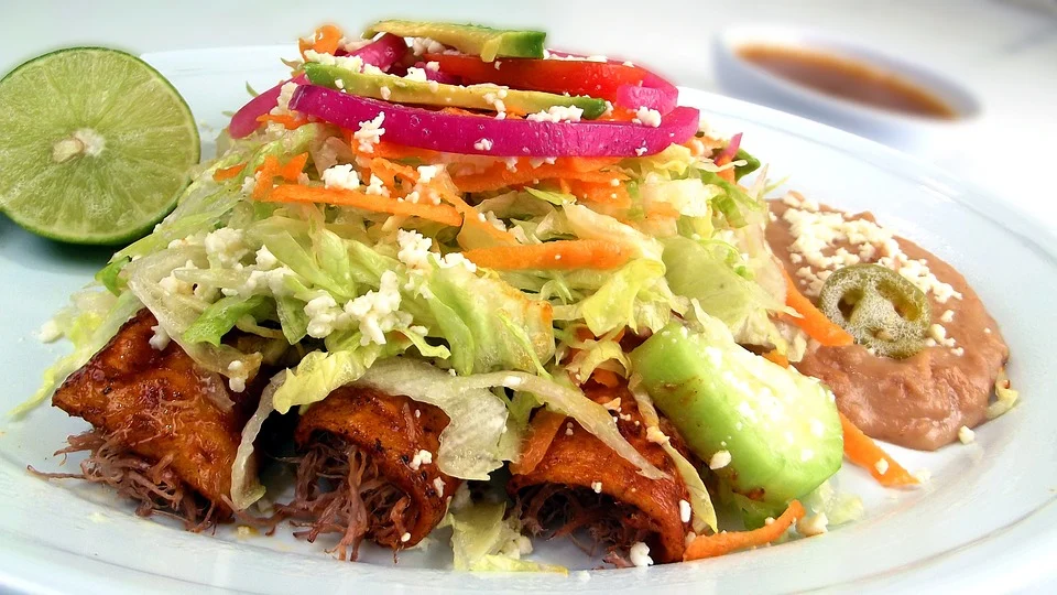 Enchiladas rellenas, acompañadas con variedad de vegetales y medio limón. | Foto: Pixabay