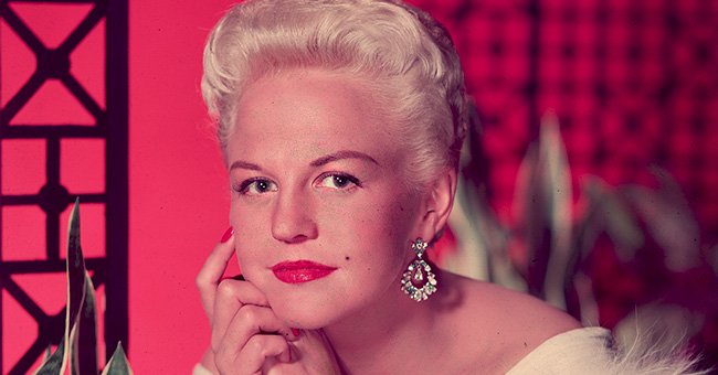 Studio portrait of singer Peggy Lee (1920 - 2002) wearing a fur- trimmed white gown and diamond earrings | Photo: Getty Images