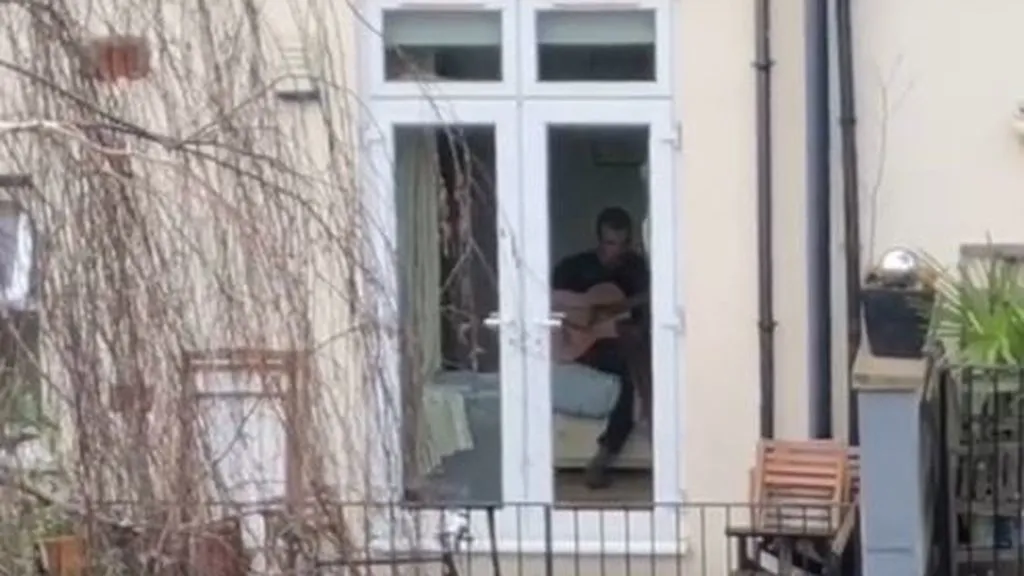 El hombre tocando su guitarra en su casa. | Foto: Captura de TikTok/ a129593a.