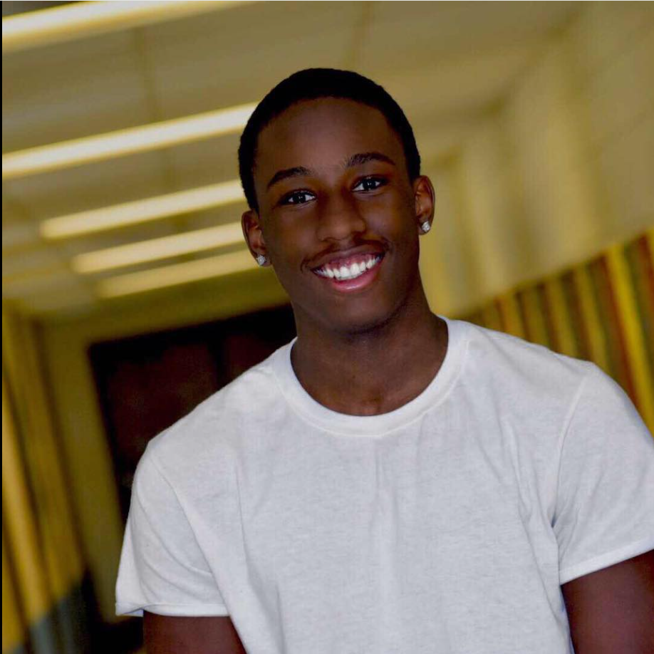 Wearing a white T-shirt and earrings, William Davis poses for a cheerful close-up portrait. | Source: Facebook/William Davis