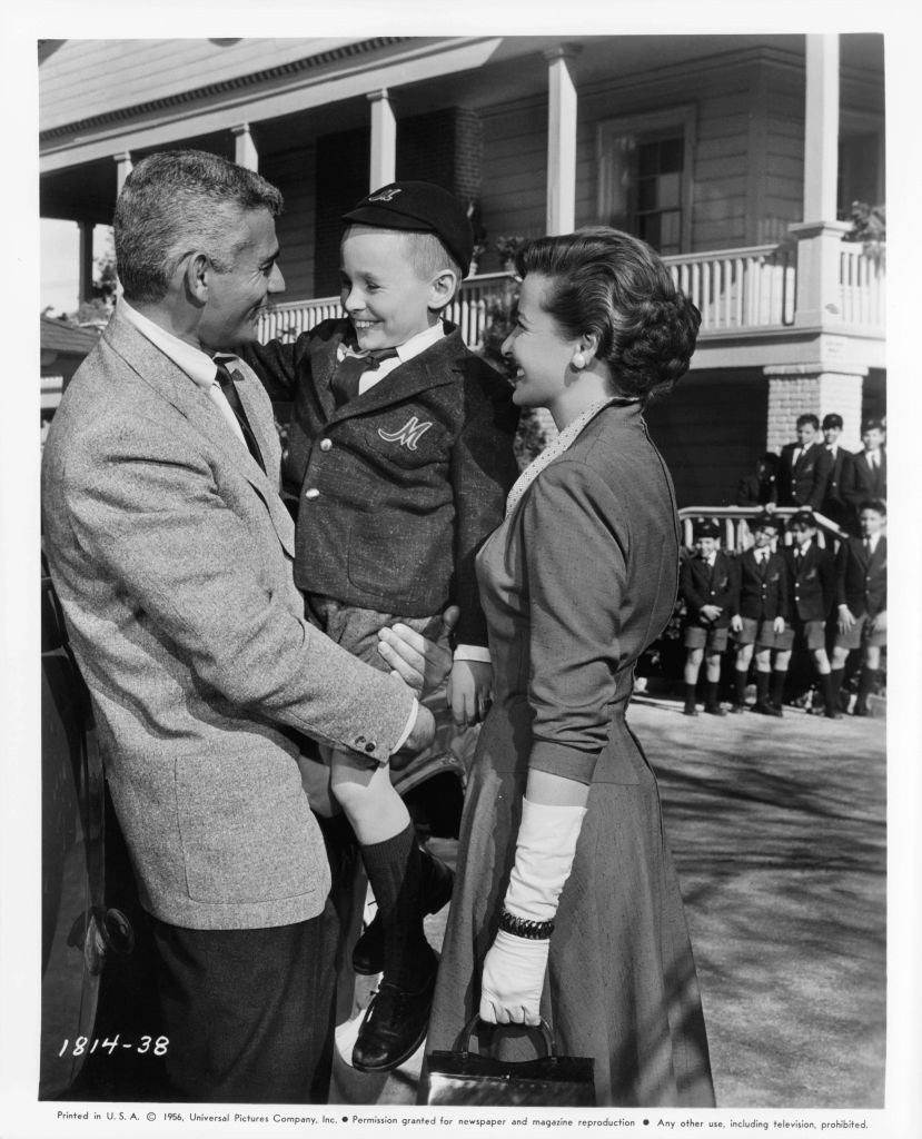 Jeff Chandler holding Tim Hovey as Laraine Day watches in a scene from the film "The Toy Tiger" in 1956. | Source: Getty Images