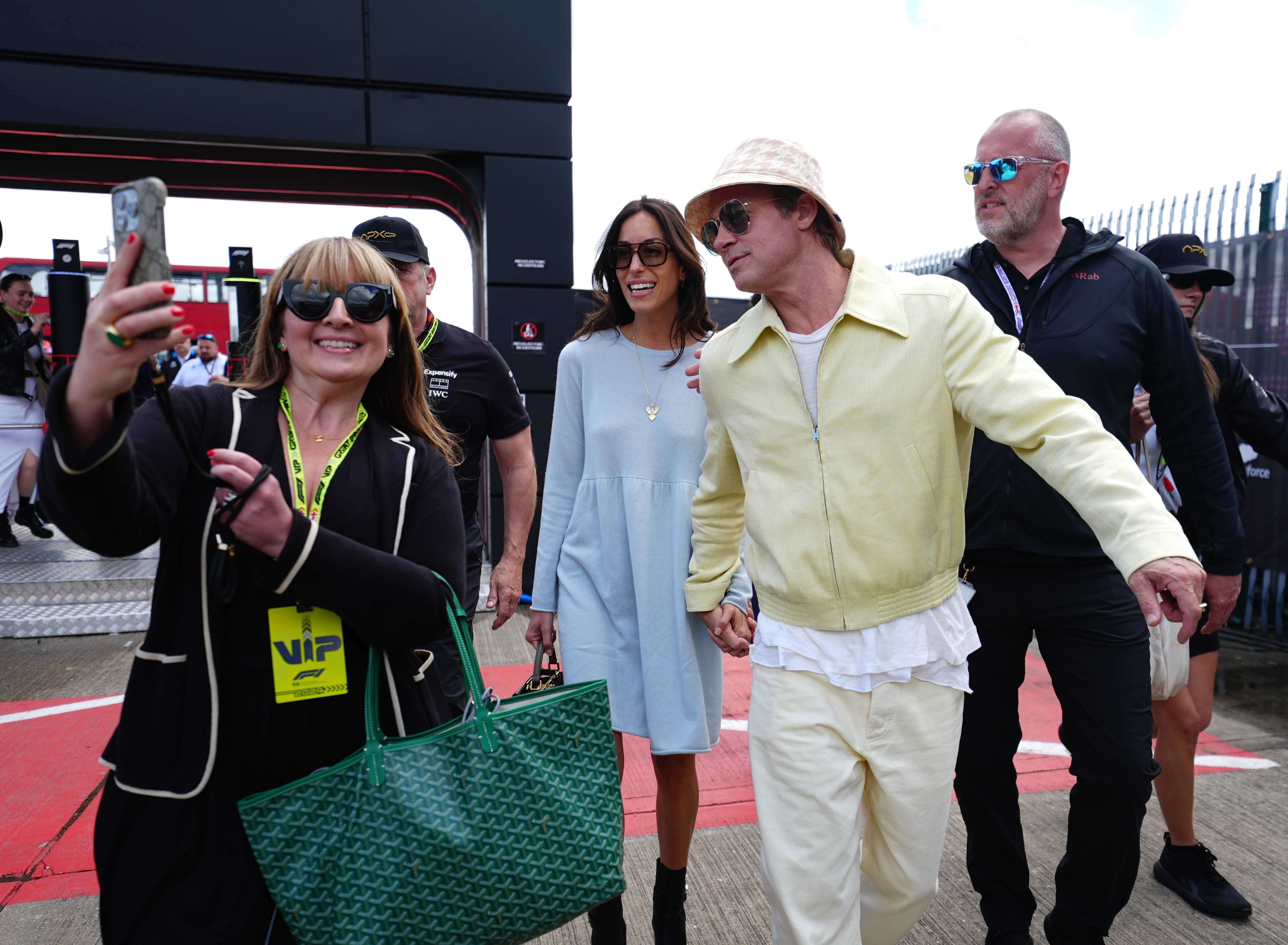 Ines de Ramon and Brad Pitt posing for a picture with a fan at the F1 Grand Prix of Great Britain at Silverstone Circuit in Northampton, England on July 7, 2024 | Source: Getty Images