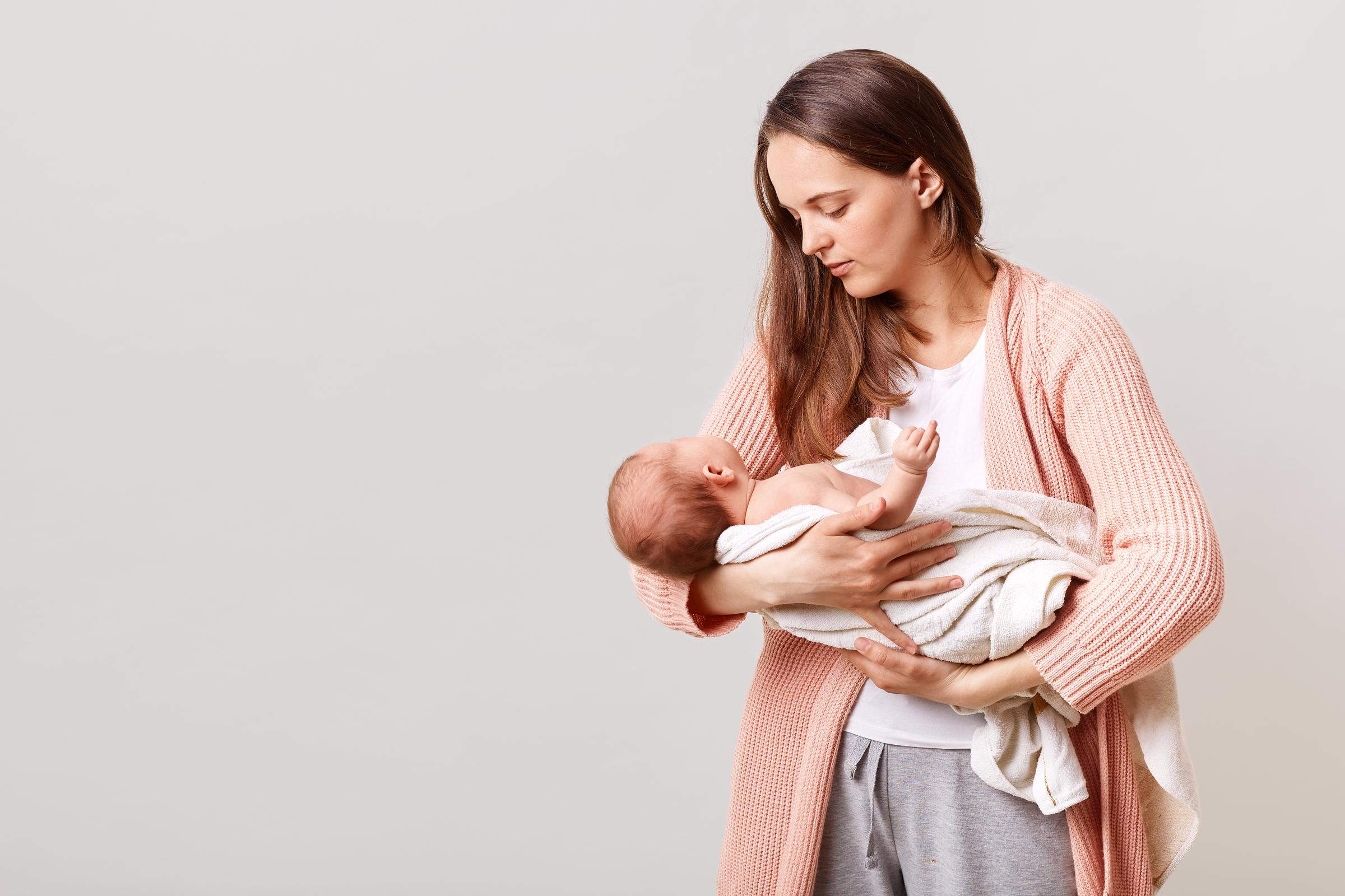 A woman holding a baby | Source: Freepik