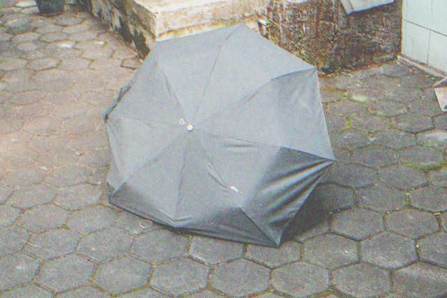 Broken old little black umbrella | Source: Shutterstock