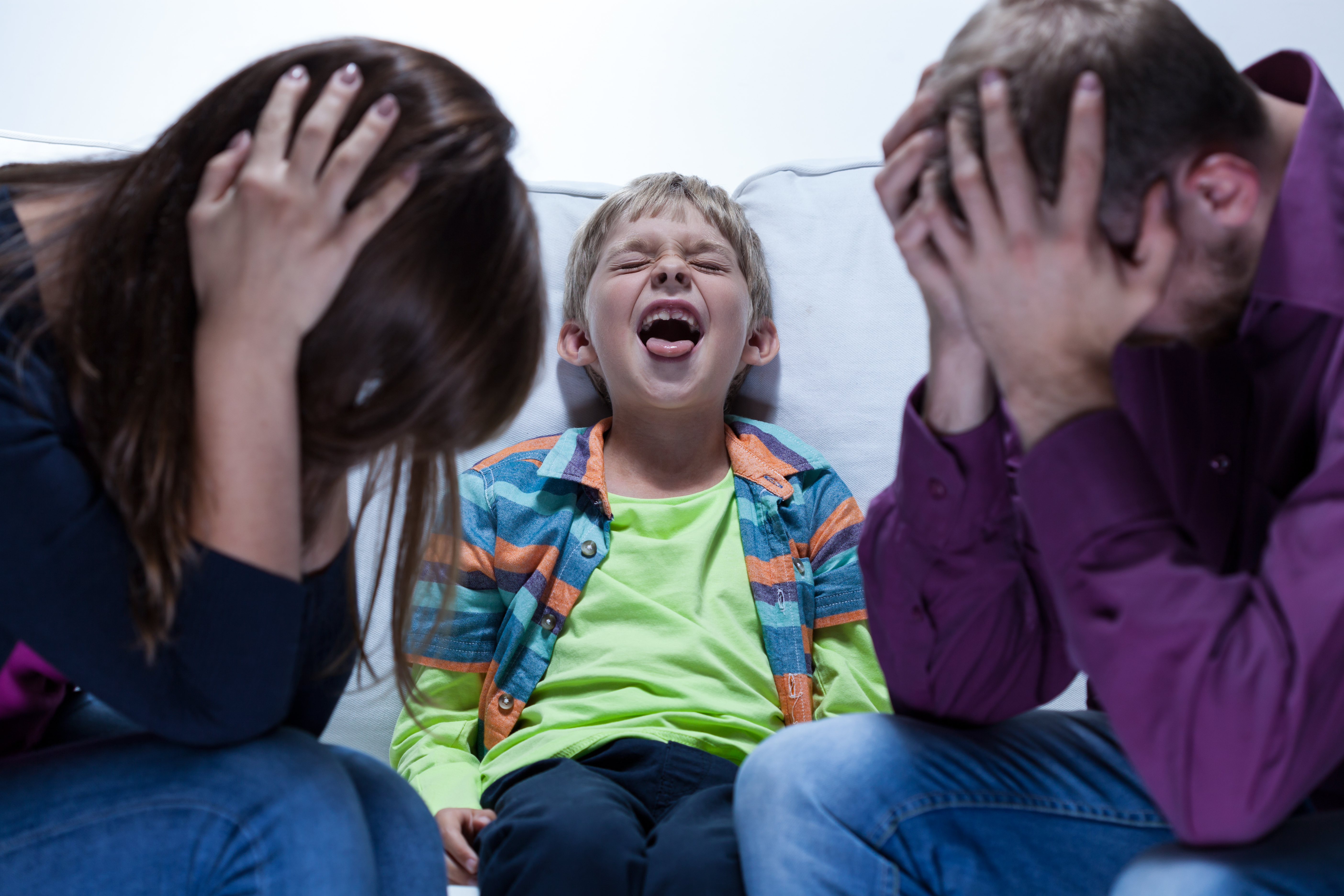 Stressed parents with their kid screaming | Source: Shutterstock