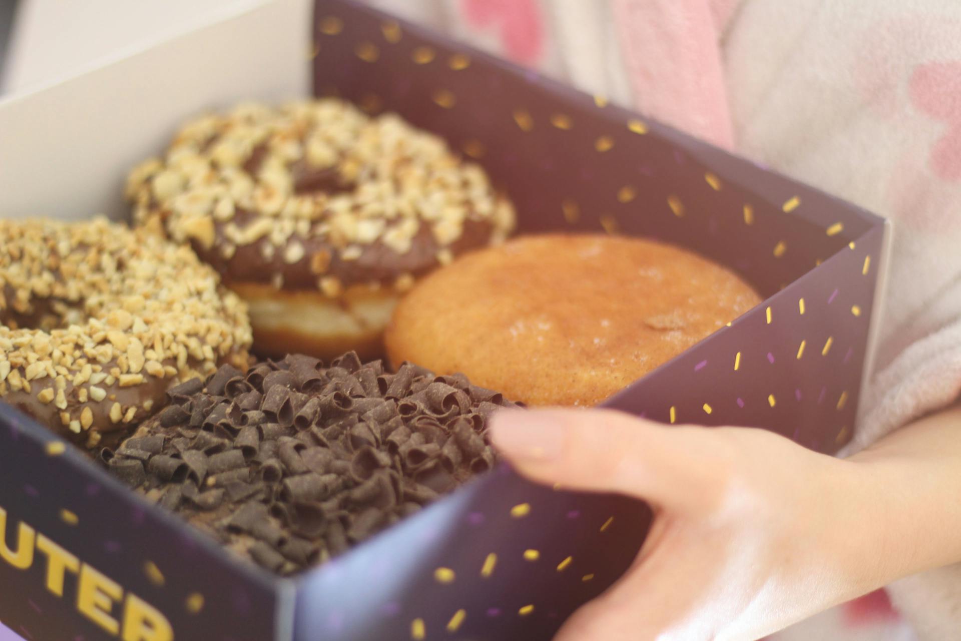 Person holding a box of donuts | Source: Pexels
