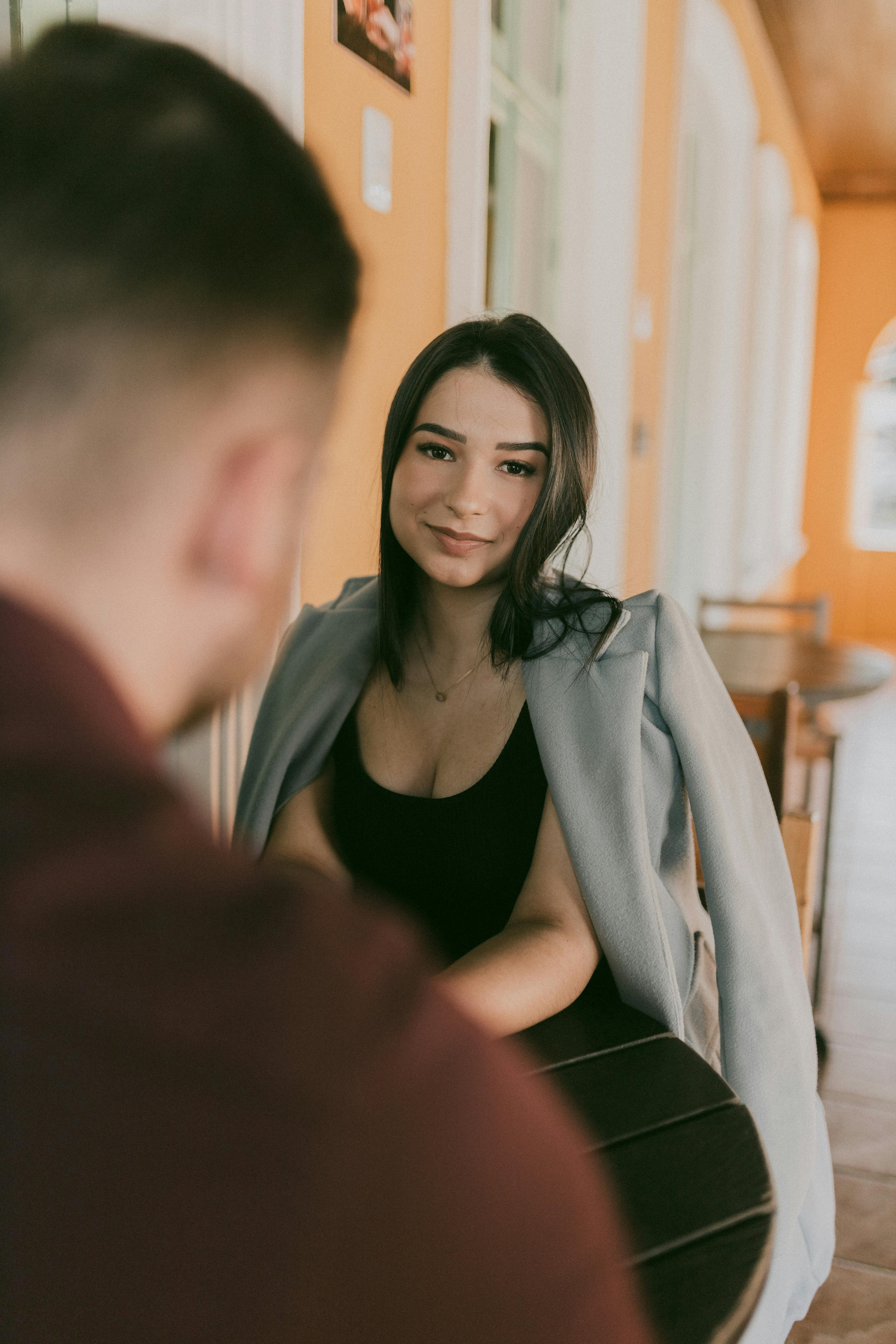 A woman smiling while on a date | Source: Pexels