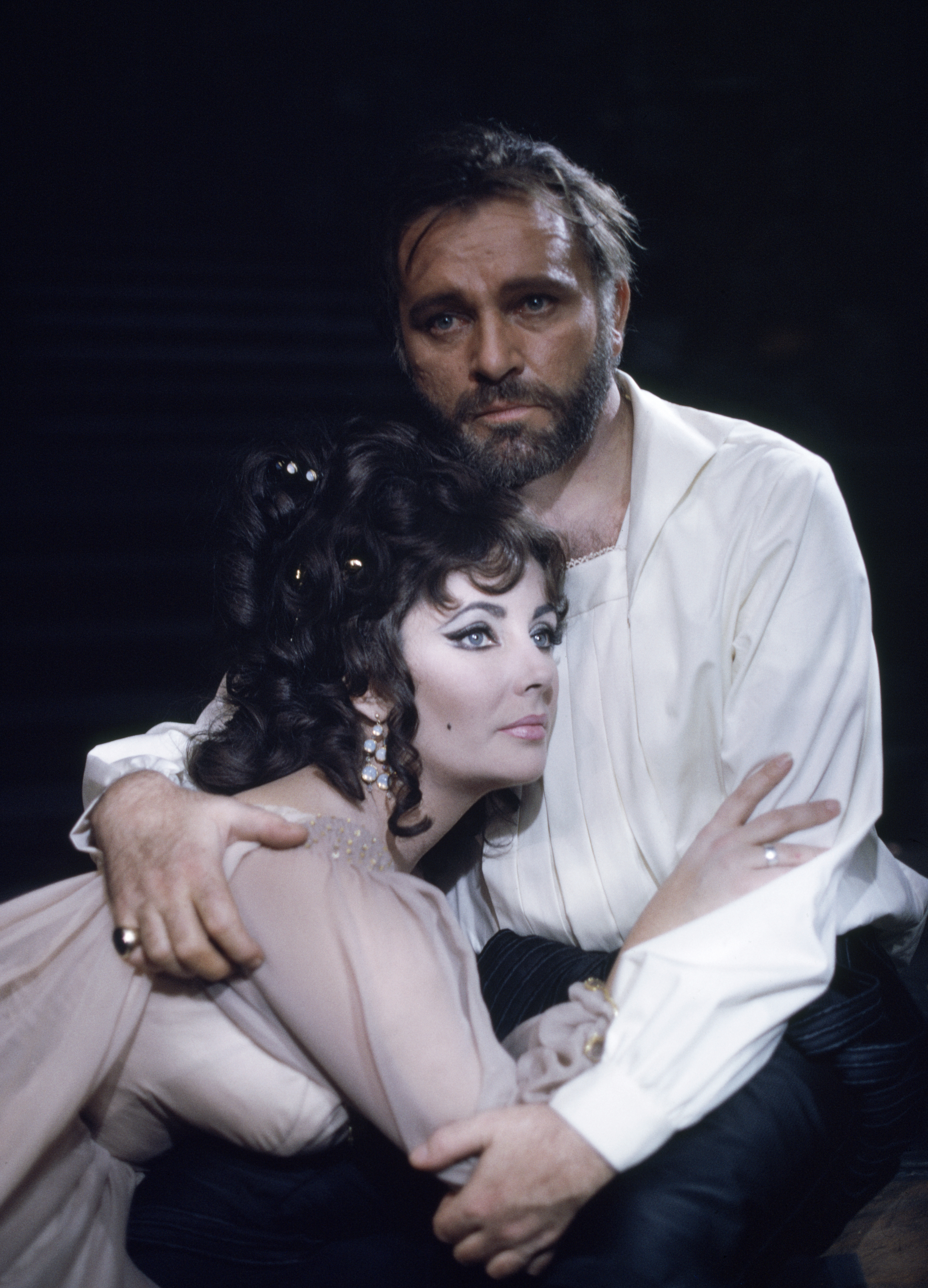 Welsh actor Richard Burton (1925-1984) and his wife, actress Elizabeth Taylor (1932-2011) in costume as 'Dr Faustus' and Helen of Troy in an Oxford University Dramatic Society production of the play by Christopher Marlowe at the Oxford Playhouse on Valentine's Day, 1966. | Source: Getty Images