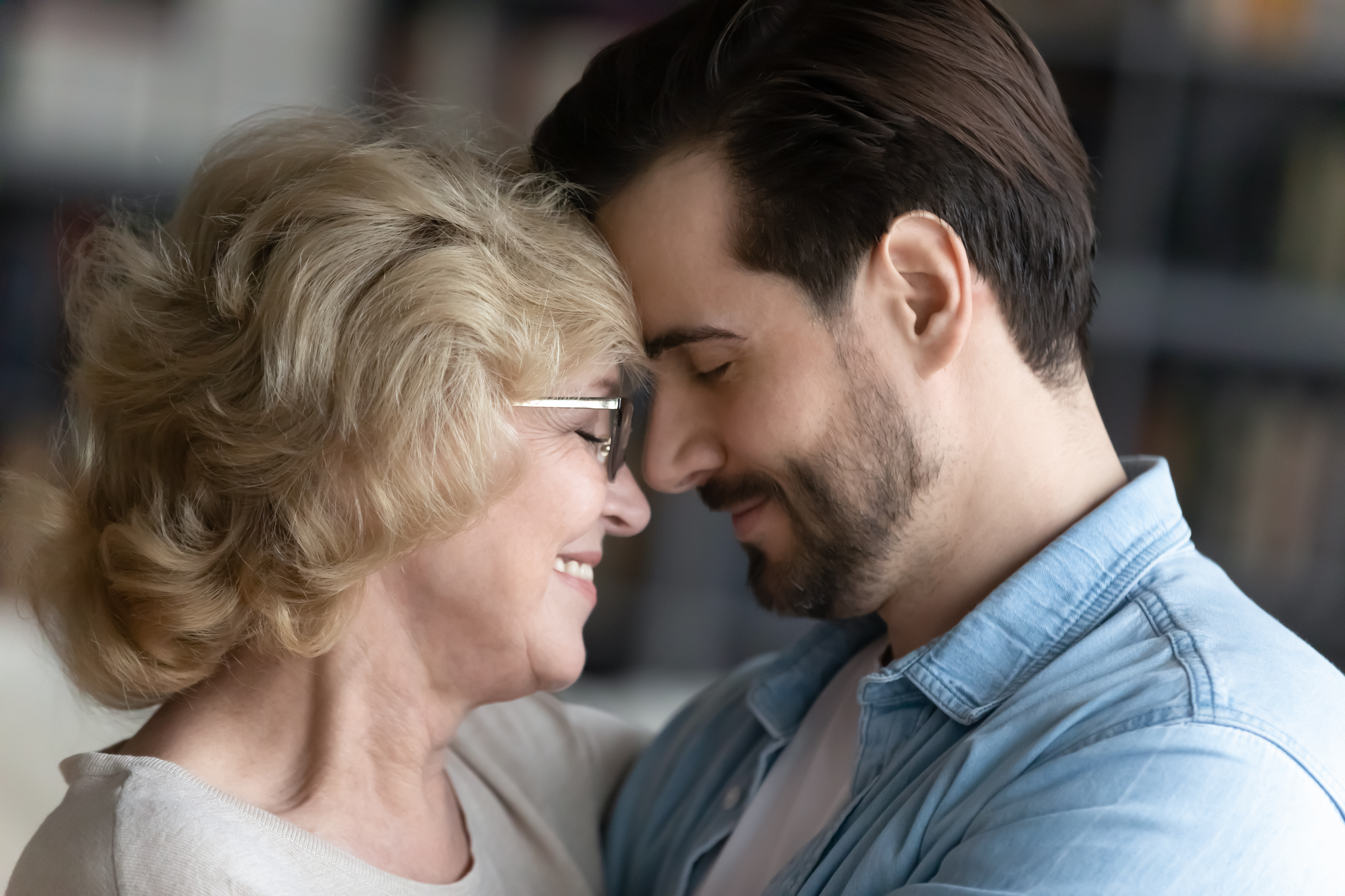 An adult son sharing a tender moment with his senior mom | Source: Shutterstock