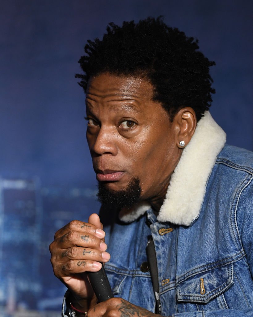 D.L. Hughley holds a microphone during his performance at The Ice House Comedy Club on February 28, 2020, in Pasadena, California | Source: Michael S. Schwartz/Getty Images