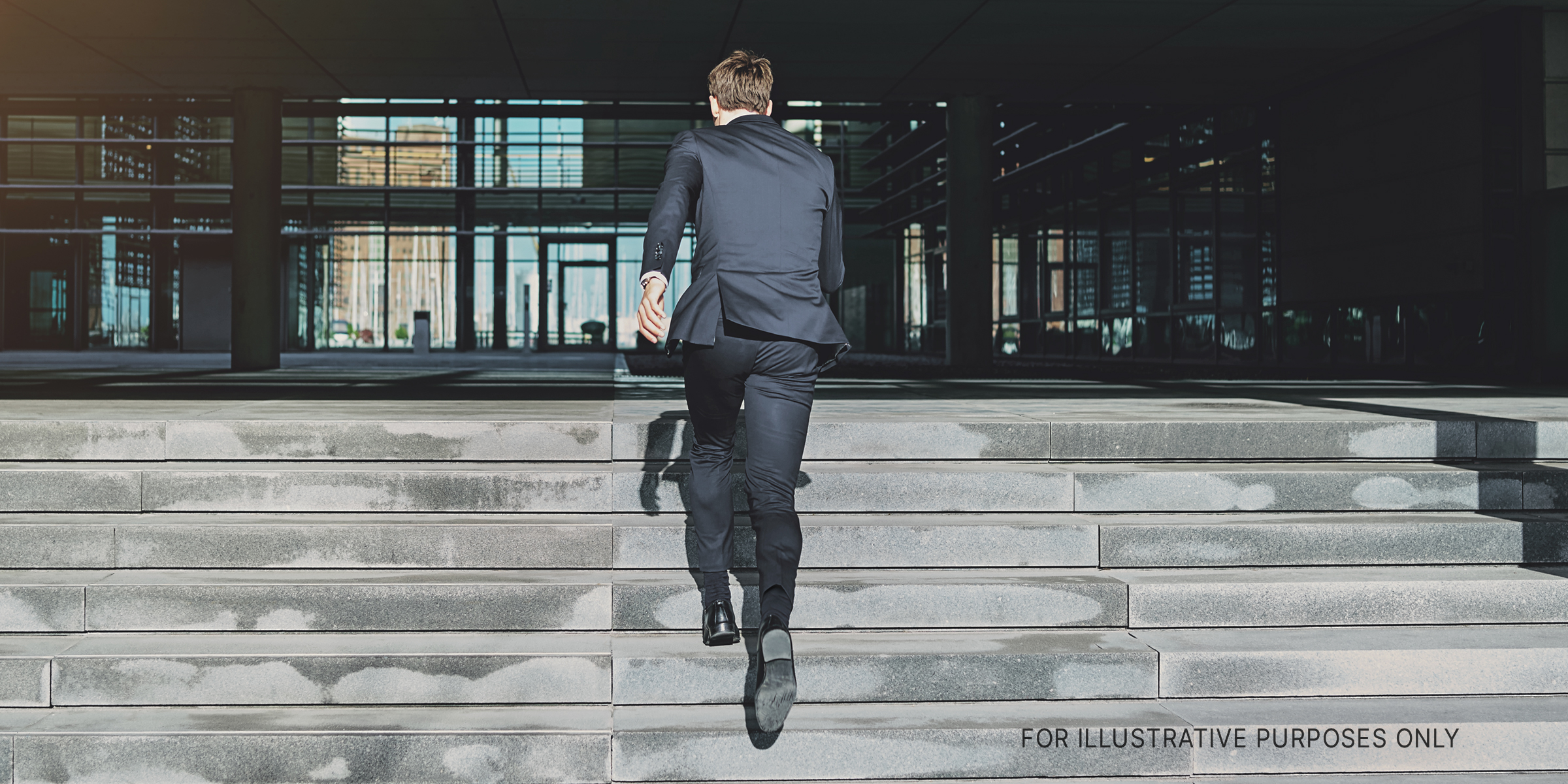 Man in suit running up steps | Source: Shutterstock