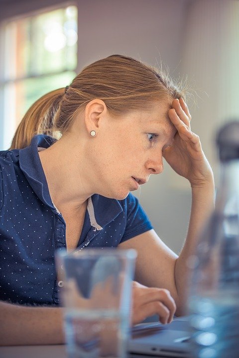 Mujer angustiada sentada frente a un escritorio. | Imagen: Pixabay