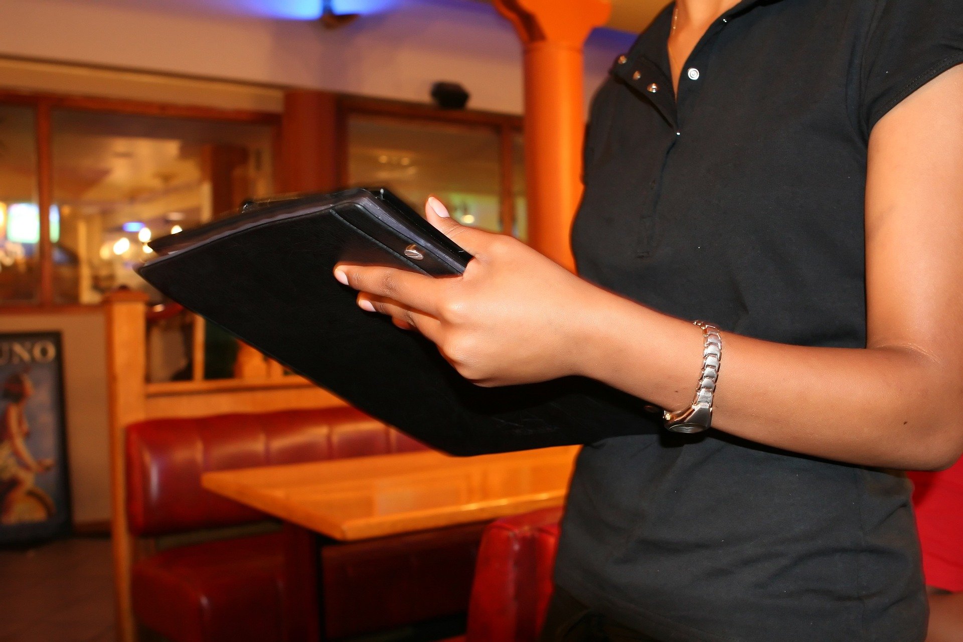 A barmaid in a bar holding a menu | Photo: Pixabay/Shutterbug75