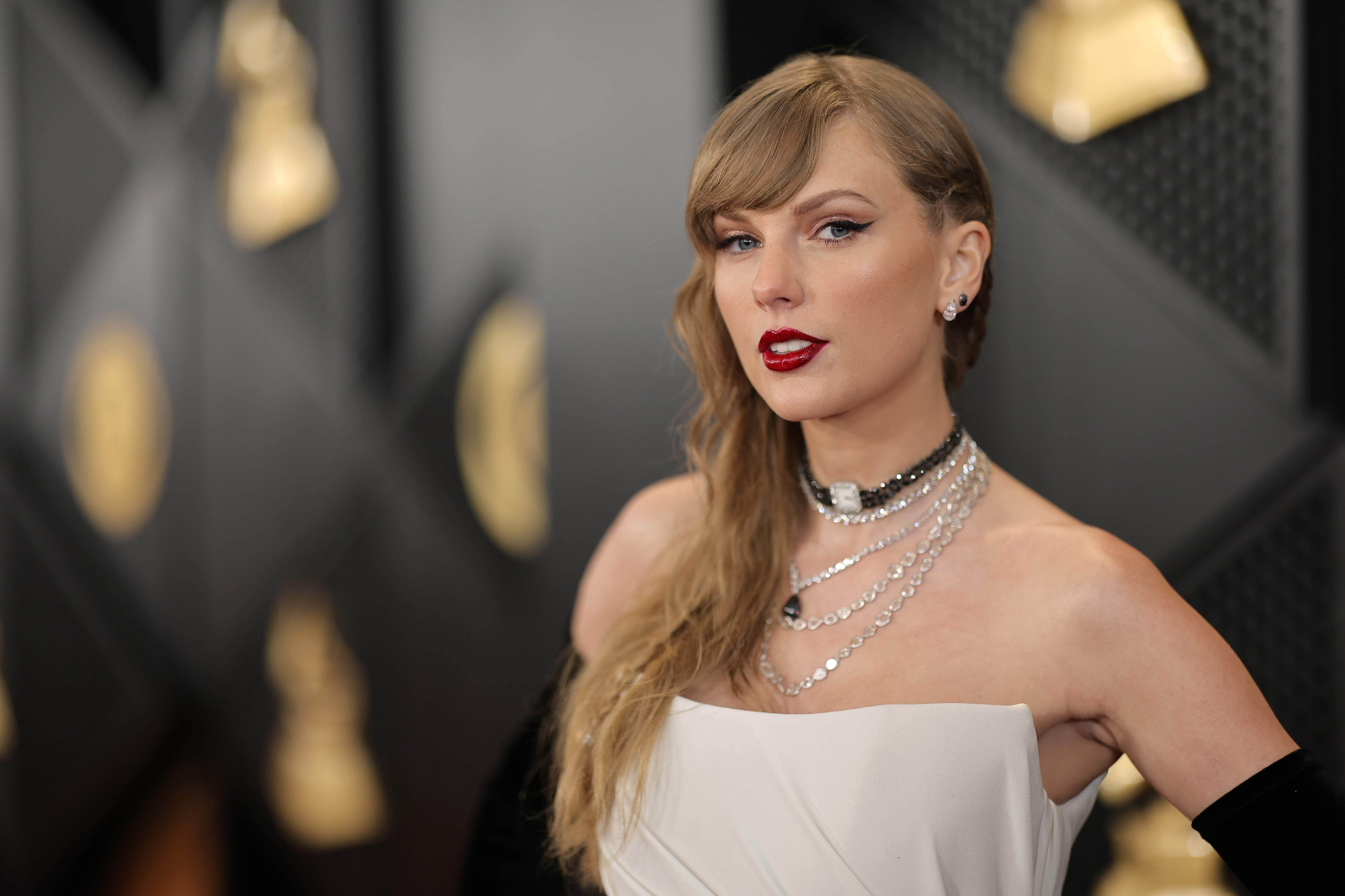 Taylor Swift attended the 66th GRAMMY Awards on February 4, 2024, in Los Angeles, California. Her soft, sculpted features were accentuated by a bold red lip, winged eyeliner, and a side-swept wave that fell just past her shoulder. With a poised expression and piercing blue eyes, she delivered a look that was both classic and confidently composed. | Source: Getty Images