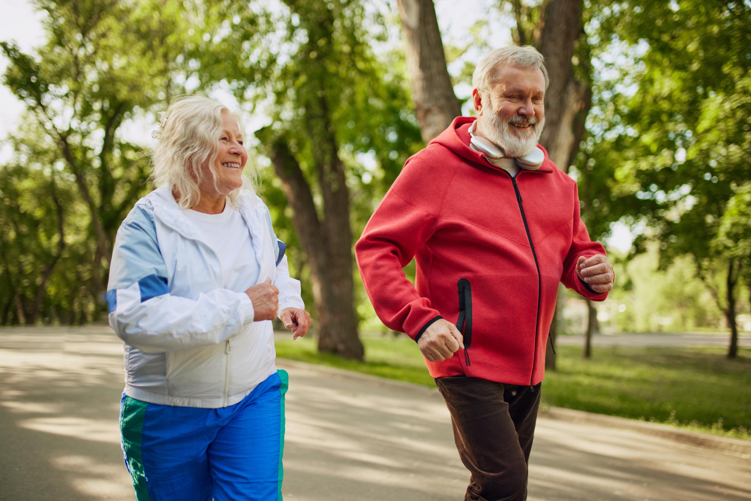 A pair of older adults jogging outdoors | Source: Shutterstock