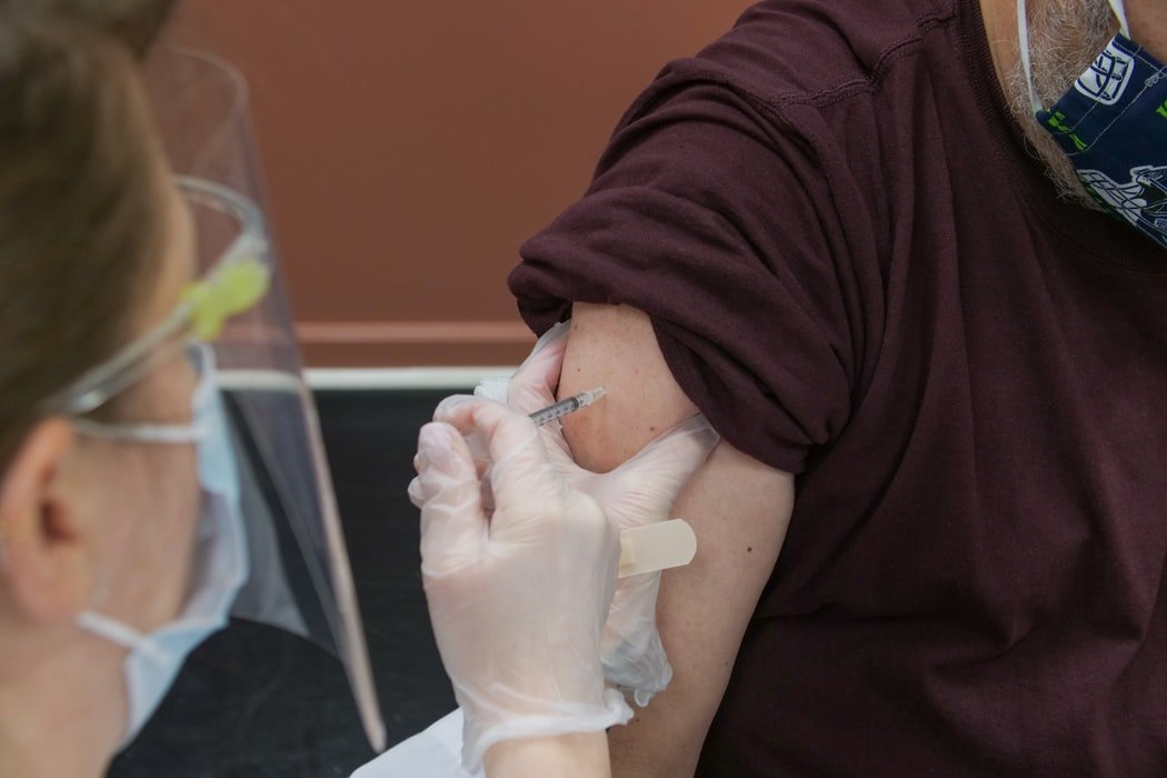 Un homme se faisant vacciner contre le COVID-19. l Source : Unsplash