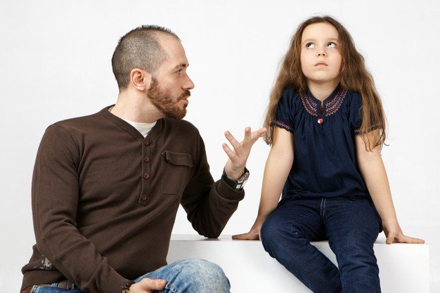 Hombre hablándole a una niña. | Foto: Freepik