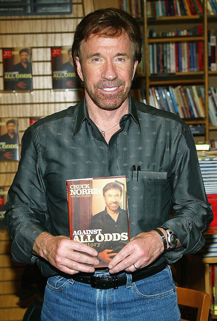 Chuck Norris holding "Against All Odds," one of his books | Photo: Getty Images