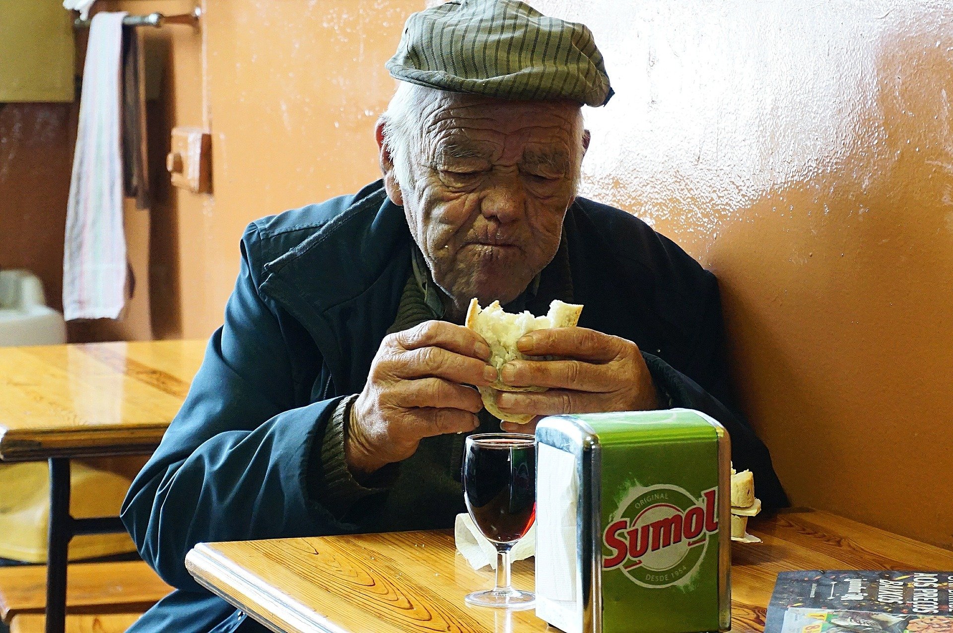 An old man sitting and eating a meal at a restaurant | Photo: Pixabay/Antonio Valente